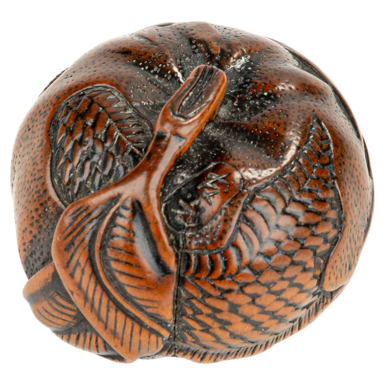 A boxwood netsuke depicting a mandarin with an engraved dragon, signed Tomomitsu in vendita