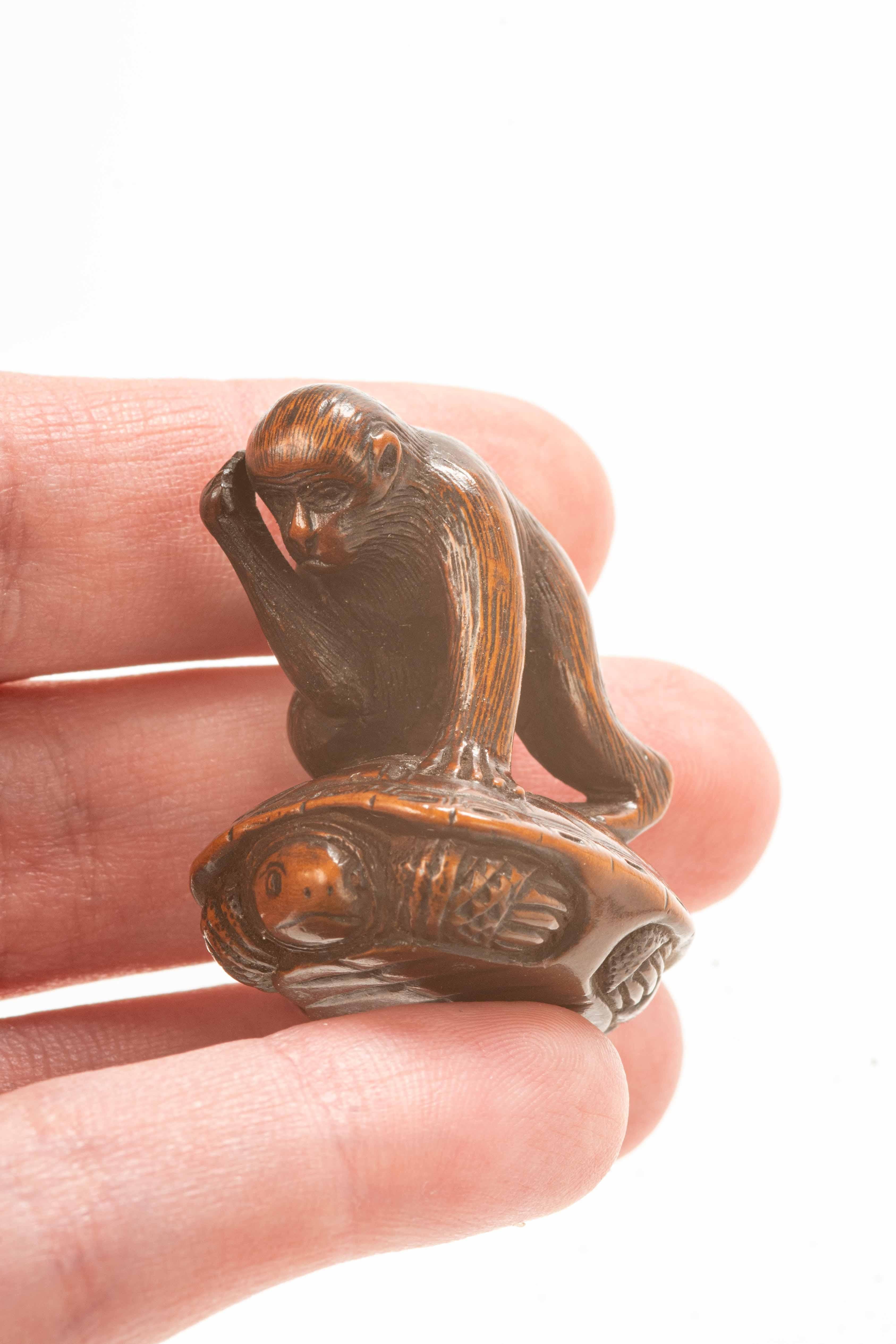 Carved A boxwood netsuke depicting a monkey trying to catch a turtle For Sale
