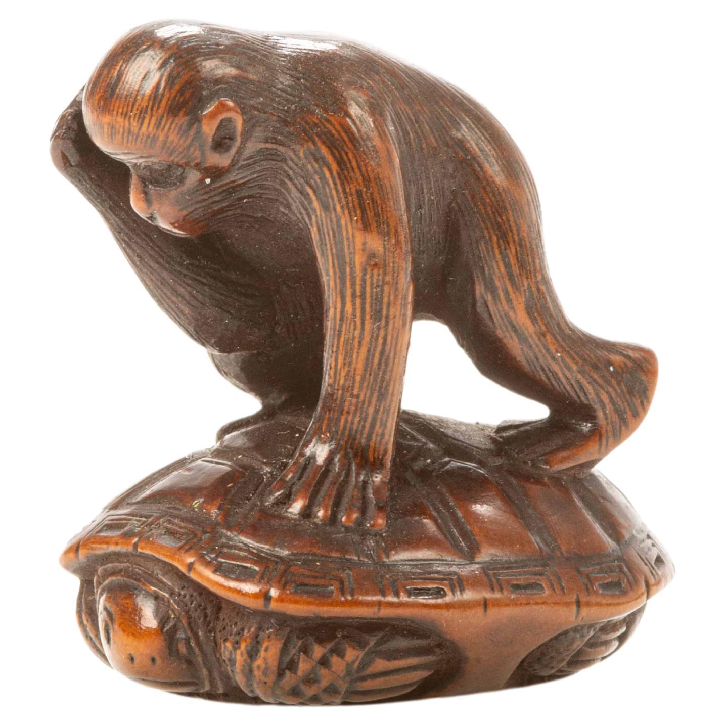 A boxwood netsuke depicting a monkey trying to catch a turtle For Sale