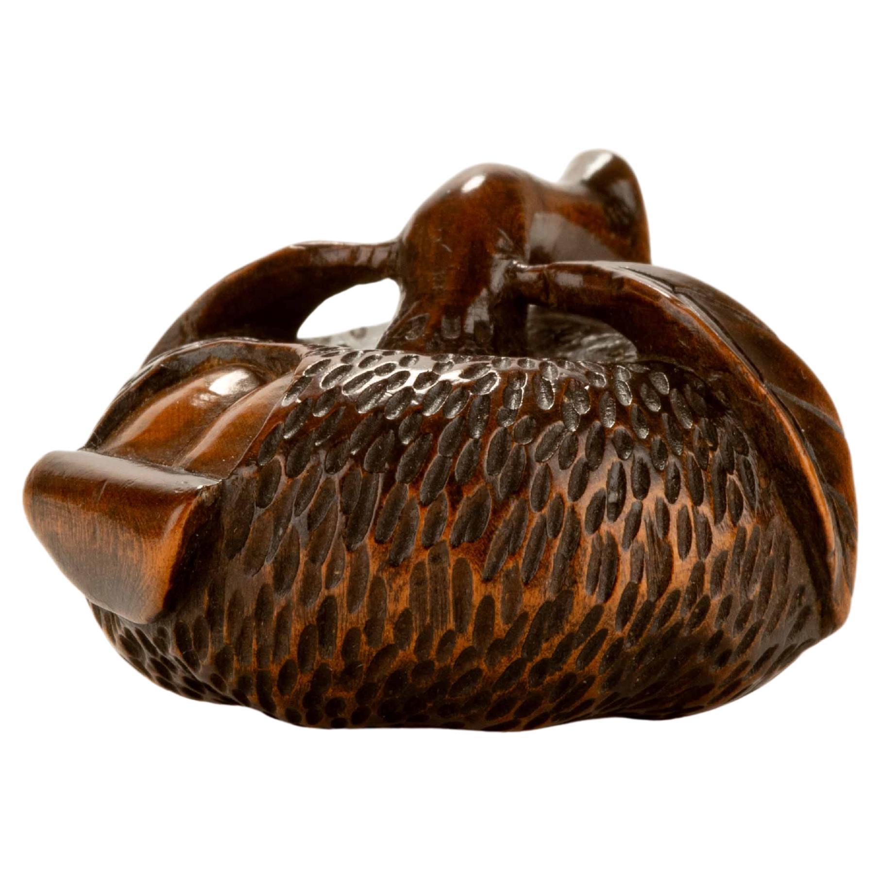 A boxwood netsuke depicting a peeled mandarin