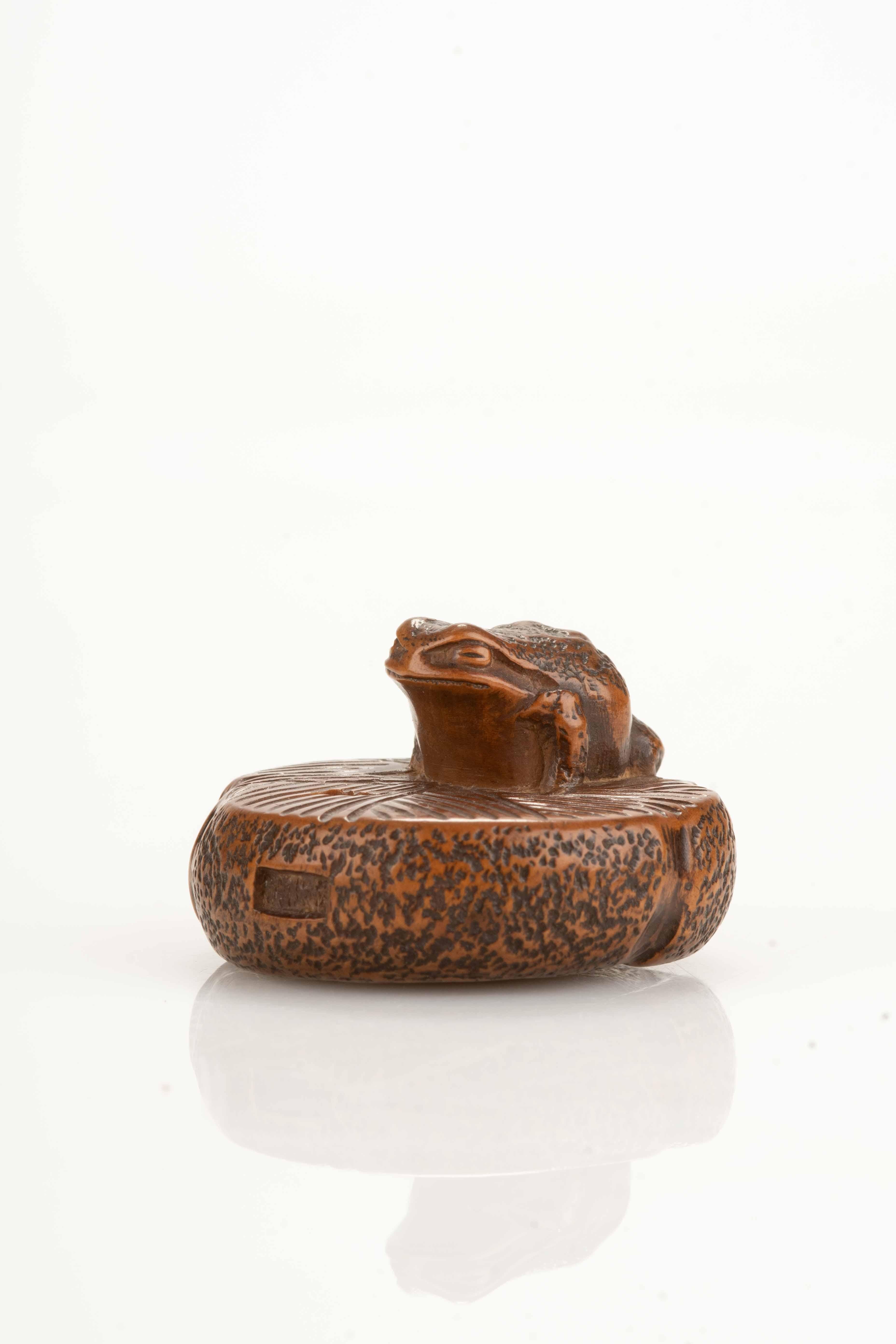 Japonisme A boxwood netsuke depicting a toad on a circular stone millstone, signed Masanao For Sale