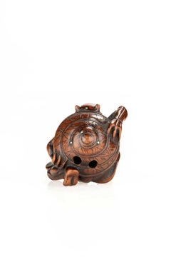 A boxwood netsuke depicting an Oni and the Setsubun festival