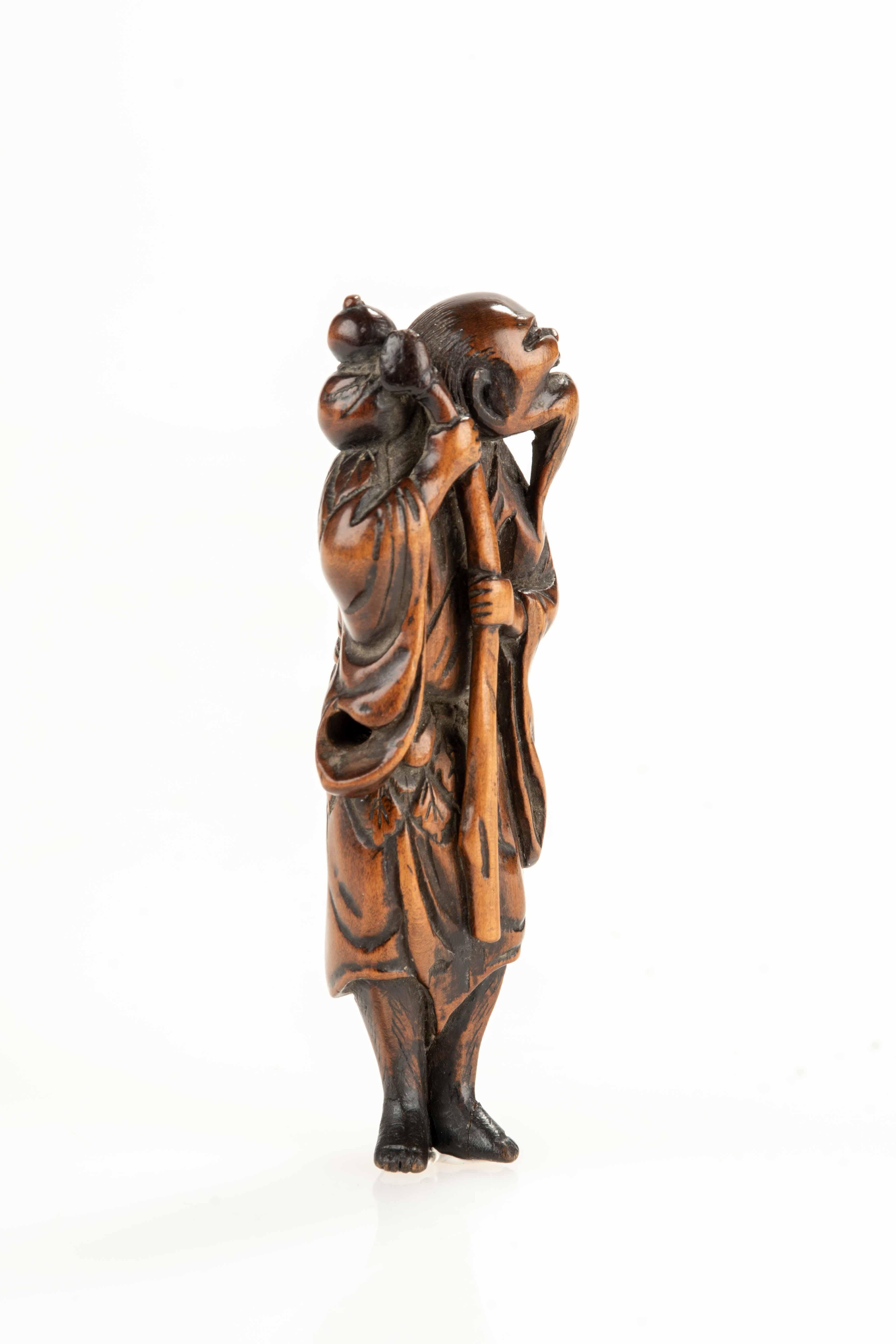 Japanese Netsuke en buis représentant un sennin avec une bouteille de saké en vente