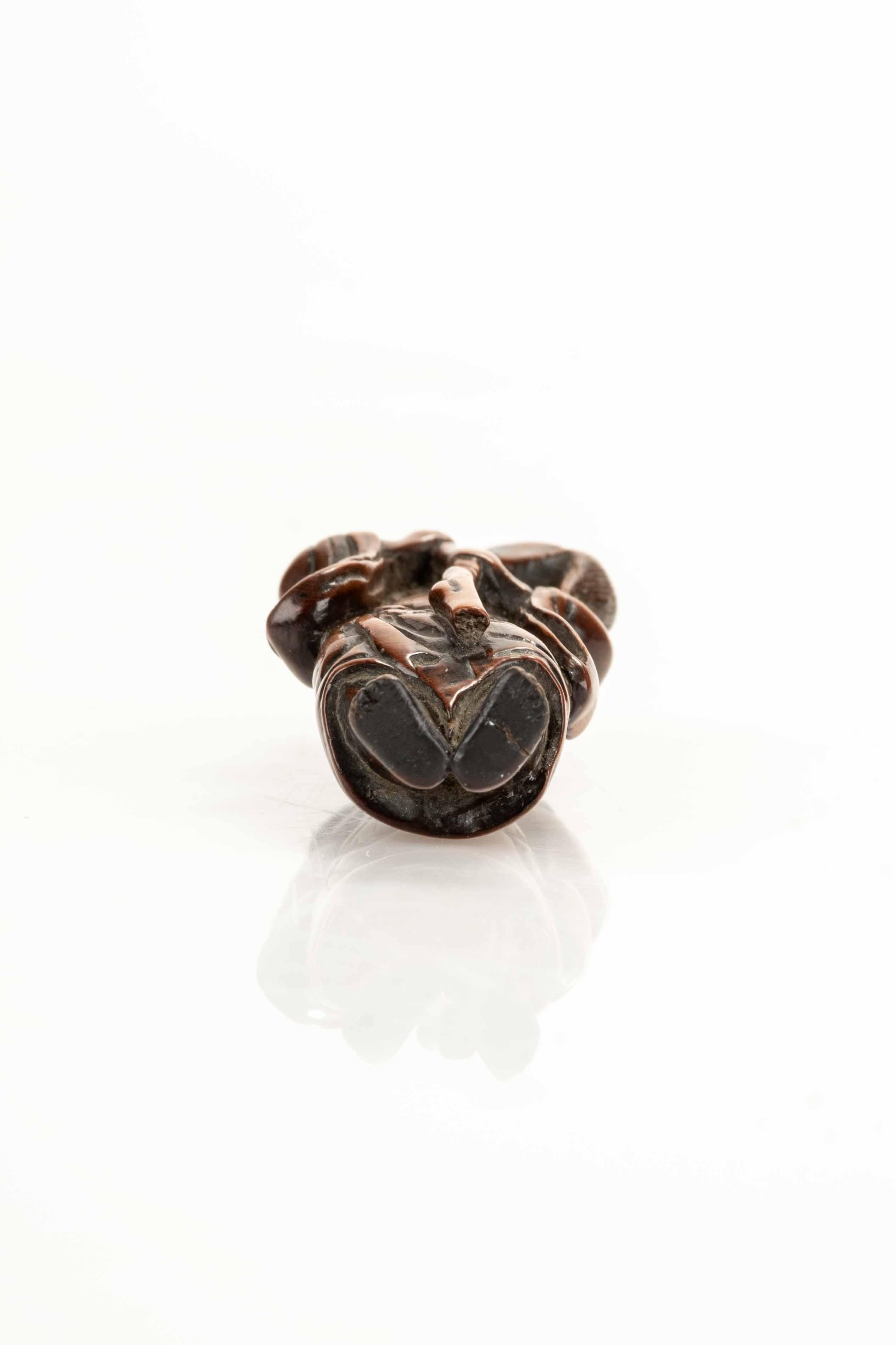 Sculpté Netsuke en buis représentant un sennin avec une bouteille de saké en vente