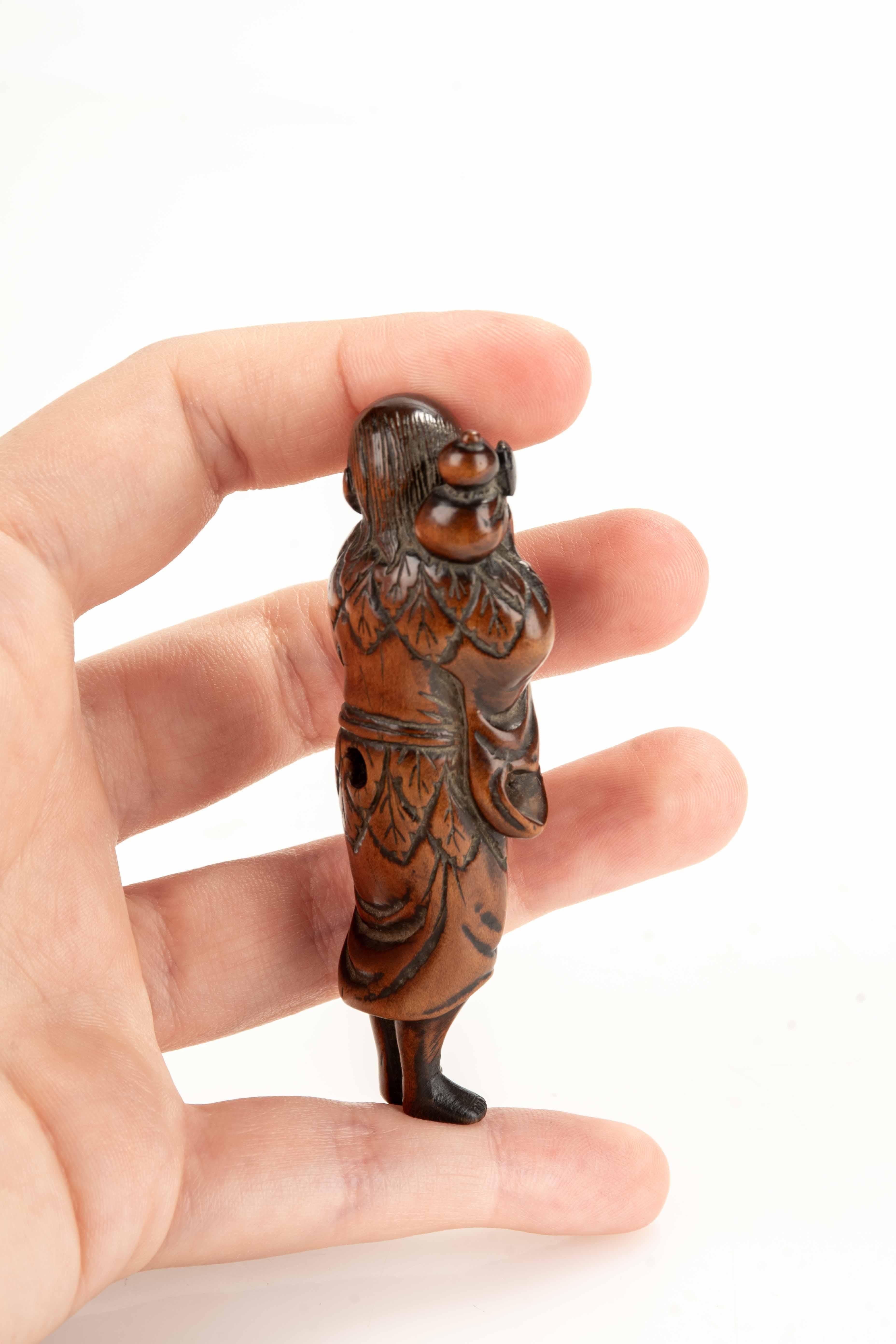 Buis Netsuke en buis représentant un sennin avec une bouteille de saké en vente