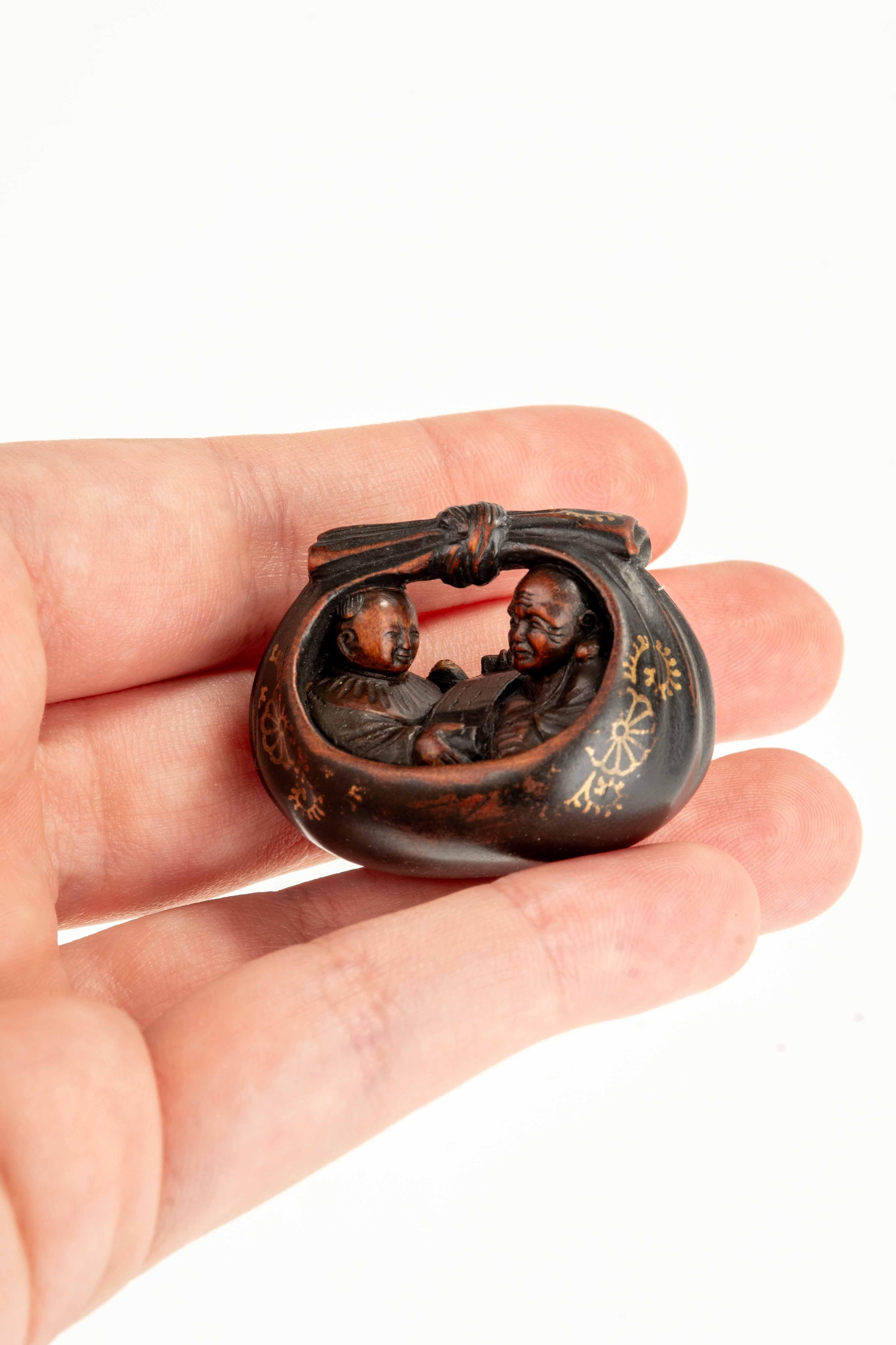 Japonais Un netsuke en buis représentant Hotei et un karako dans le sac en vente