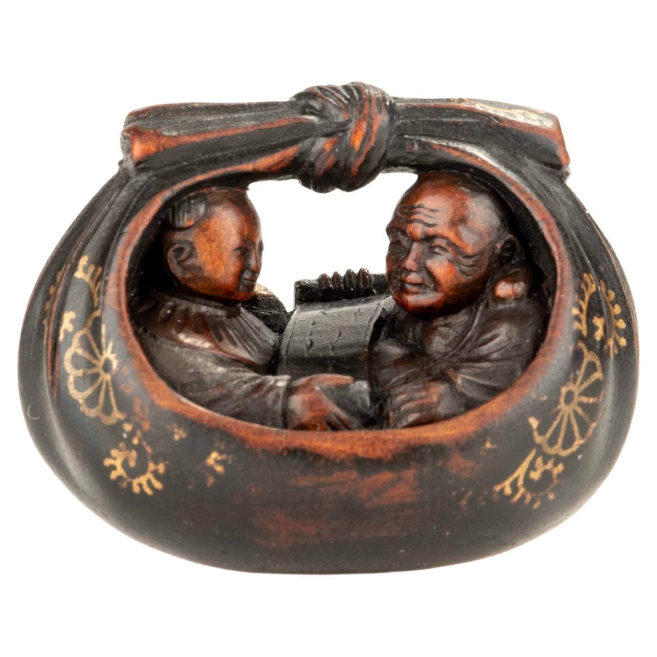 Un netsuke en buis représentant Hotei et un karako dans le sac en vente