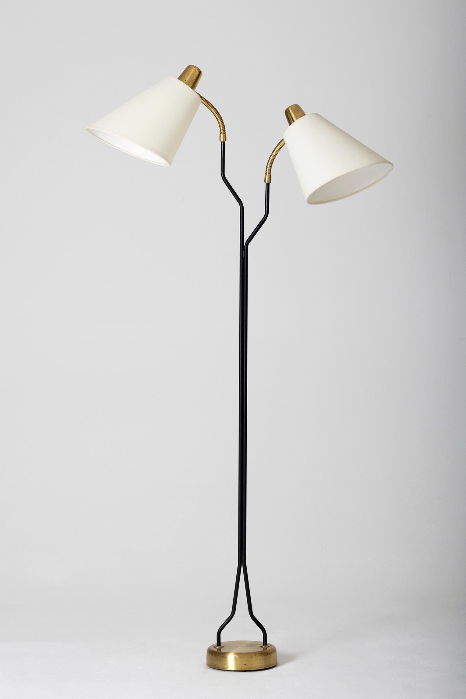 A brass and black enamelled iron two-arm floor lamp, with bespoke shades
Sweden, circa 1950
Height 147 cm, width including the shade 70 cm, diameter of the brass base 18 cm.