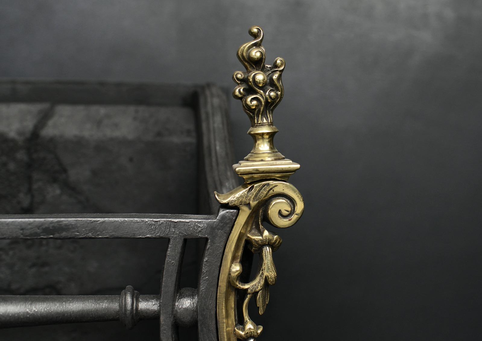 Grille à feu rococo en laiton et en acier du XIXe siècle. La frette moulée de façon élaborée est flanquée de pieds en forme et surmontée de fleurons en forme de flamme. Barres frontales en fonte au centre. Français. 

Largeur à l'avant :	580 mm     