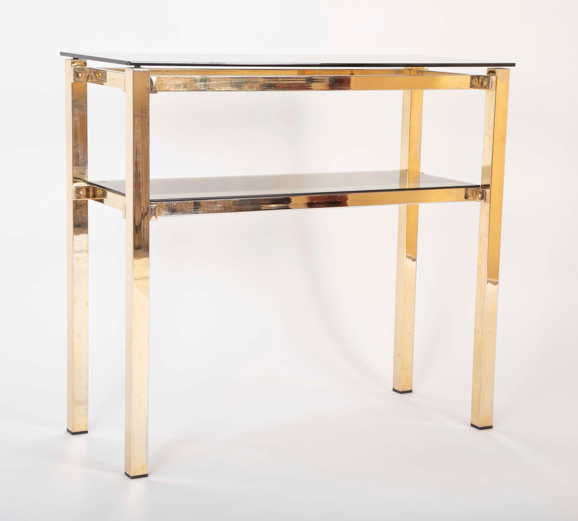A brass console table with smoked glass designed by Romeo Rega.