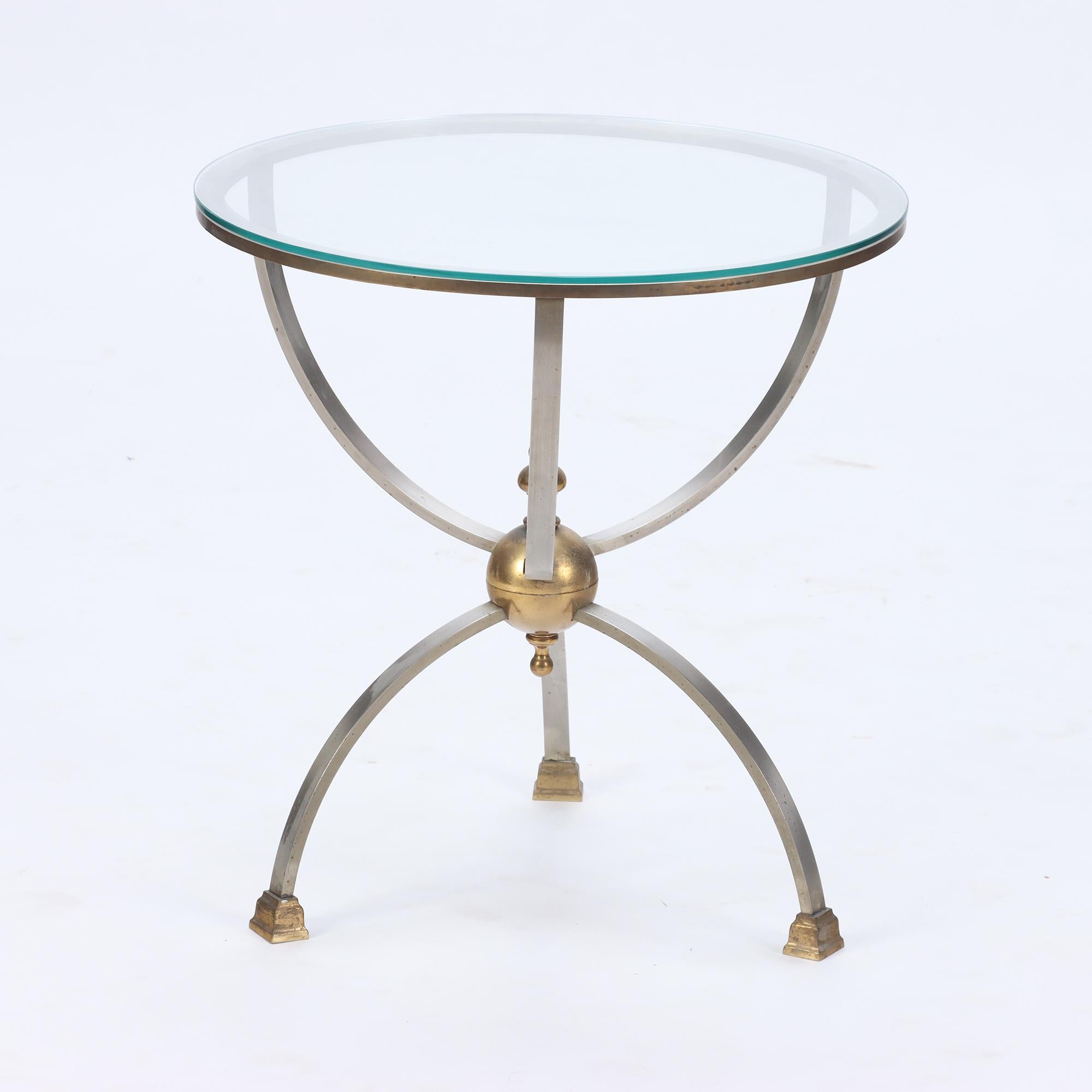 A brass and steel glass top occasional table circa 1970. In the manner of Jansen.