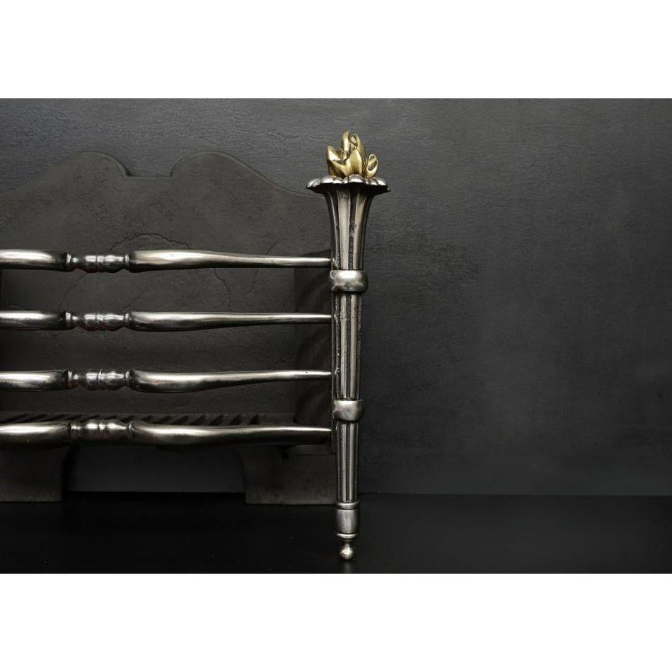 An English steel firebasket. The shaped polished cast iron front bars with tapering brass torch legs surmounted by flaming brass finials. Shaped cast iron back behind. Circa 1900.

Additional information:
Width at Front: 535 mm / 21 ⅛