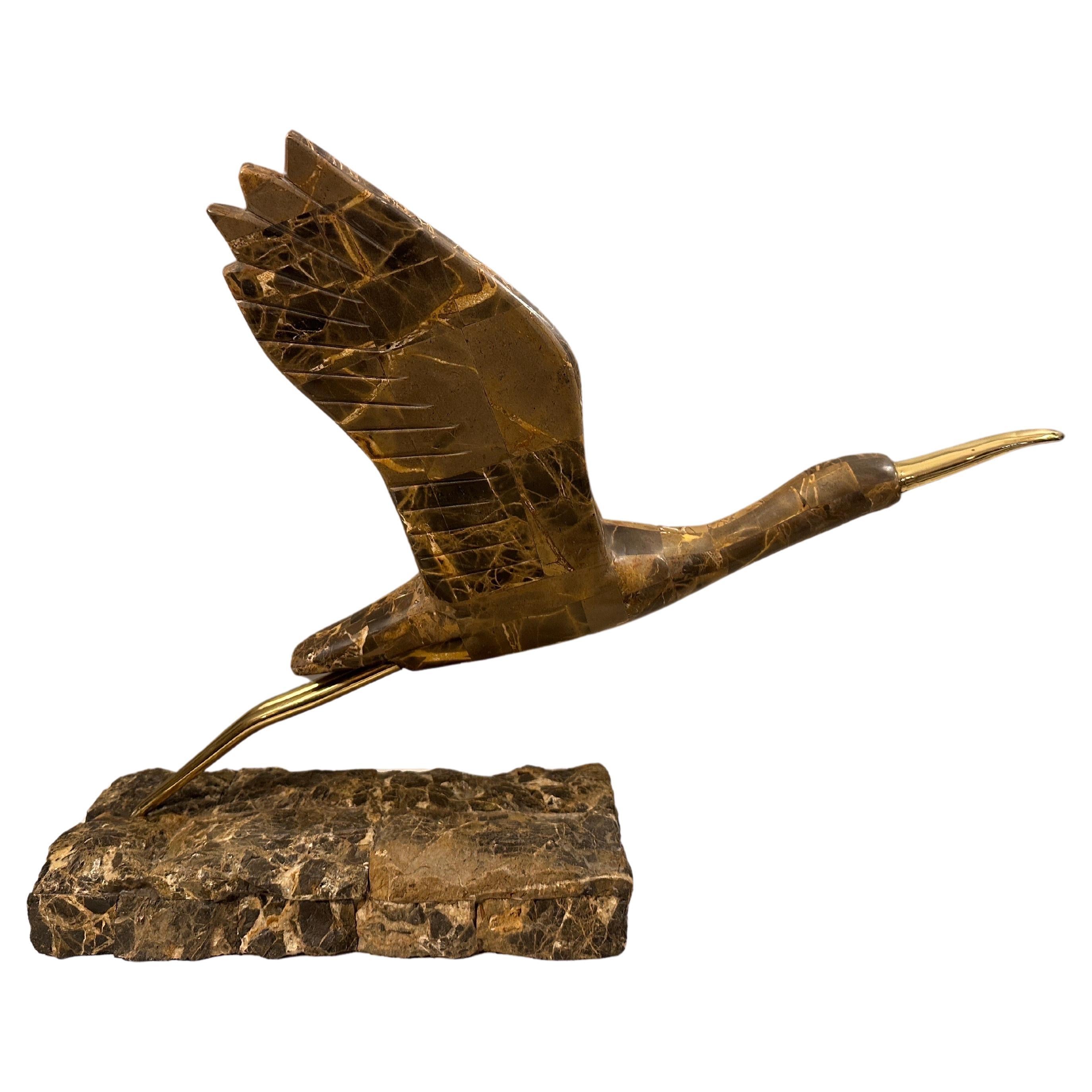 A Tessellated Emperador marble and brass bird by Maitland Smith. Captured about to take flight, with brass legs and bill. The base again in rough unpolished marble. Good scale and form, with the movement done gracefully.