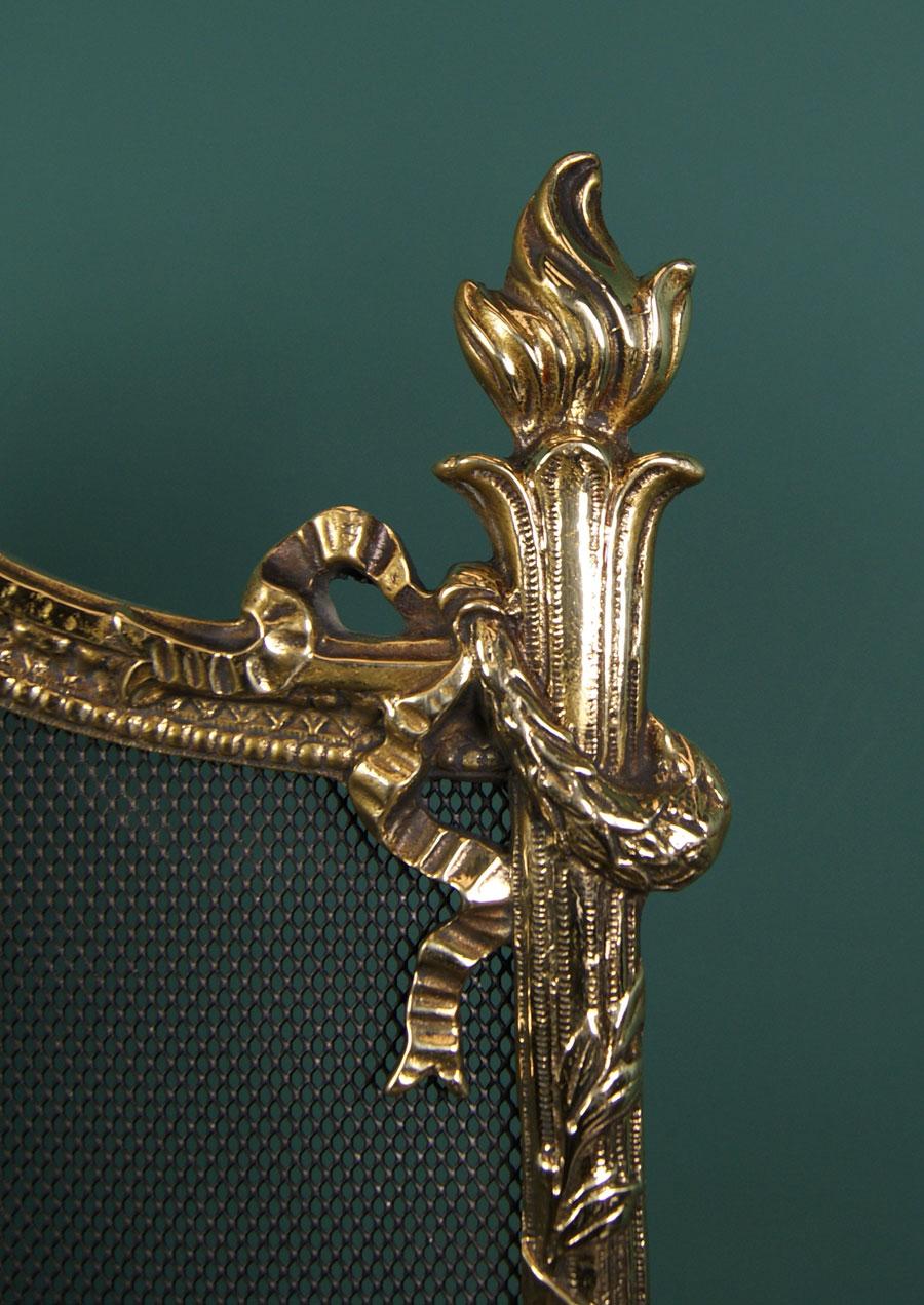 Magnifique pare-feu anglais en laiton poli de style Regency, avec des détails de couronnes et de rubans sur le cadre, une poignée circulaire florale et un cartouche central sur la base. L'écran repose sur des pieds en forme de sabot. Restauré.
Circa