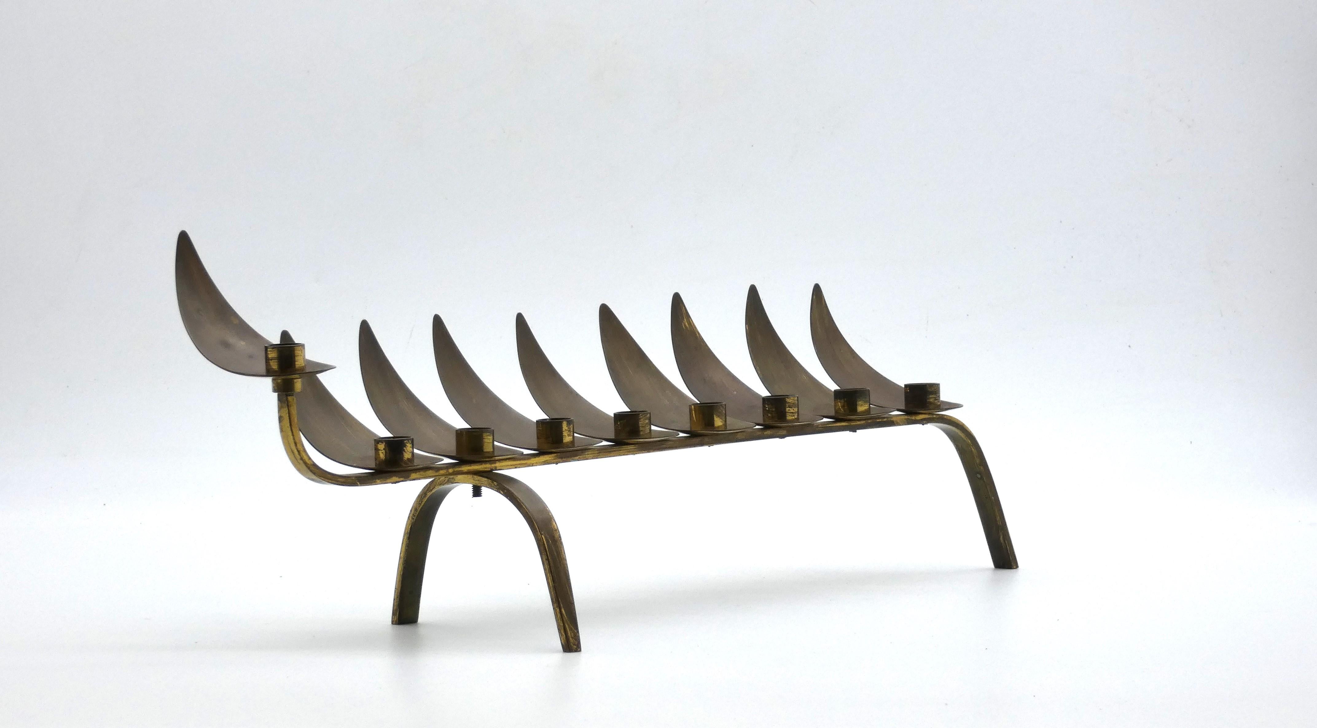 Classica lampada di Hanukkah disegnata da Ludwig Yehuda Wolpert nel XX secolo.

Questa lampada di Hannukah ha un design elegante con due sottili barre curve incrociate a un'estremità che fungono da tre gambe su cui poggia.

Otto piccole tazze