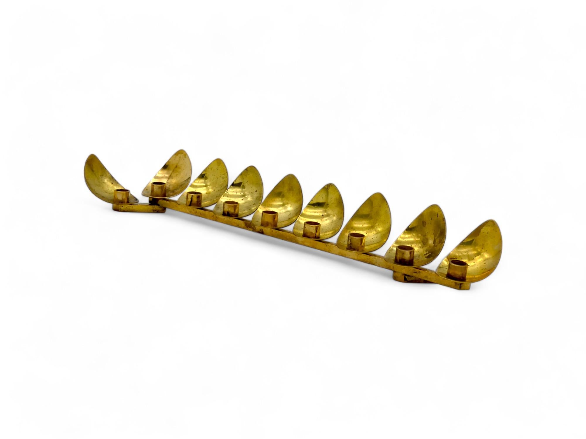 Lampada di Hanukkah in ottone Art Deco di Ludwig Wolpert realizzata in Israel negli anni '60.

Il design classico dell'Art Déco utilizza le forme geometriche che venivano usate in quel periodo per realizzare creazioni artistiche e in questo caso,