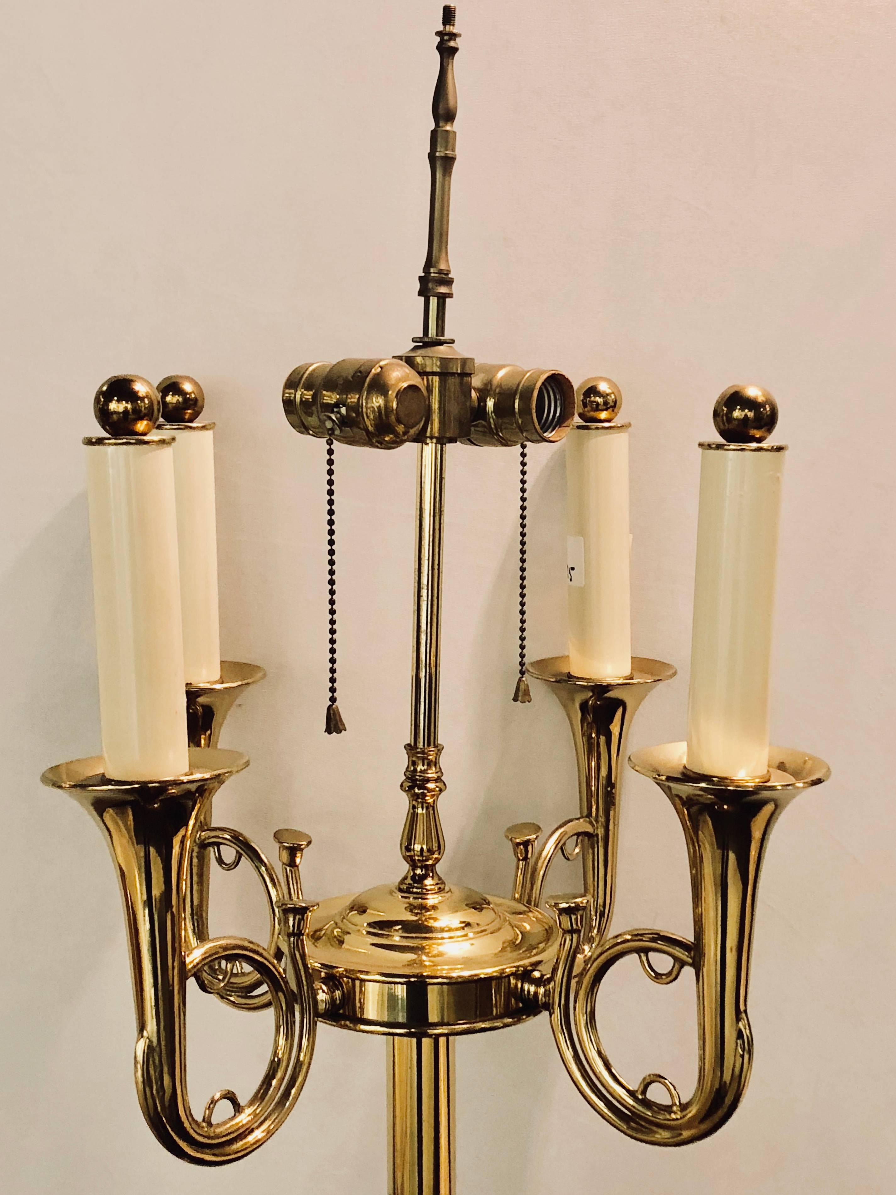 A brass Hollywood Regency Tommi Parzinger style trumpet form floor lamp. The height of lamp is measured from top of ball to the base. This standing lamp comes without a shade and is solid brass.
