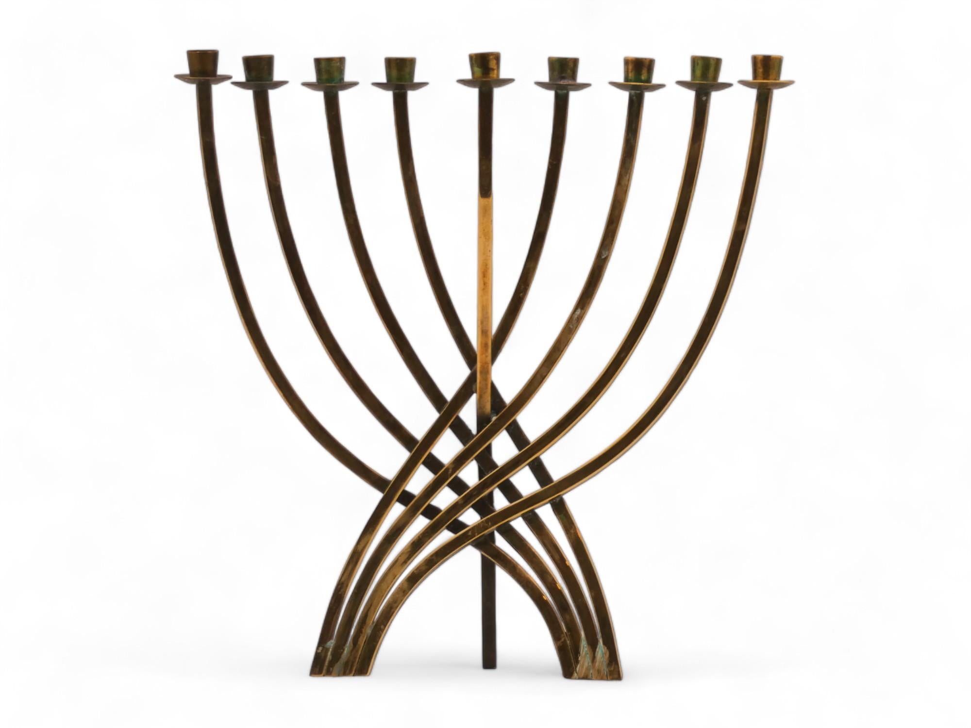 Brass Menorah by Ludwig Yehuda Wolpert is a reproduction of a minimalist branch menorah with a Bauhaus styling designed by Ludwig Yehuda Wolpert.

Menorah is made up of nine long squared brass stems crisscrossing at the center and curving their way