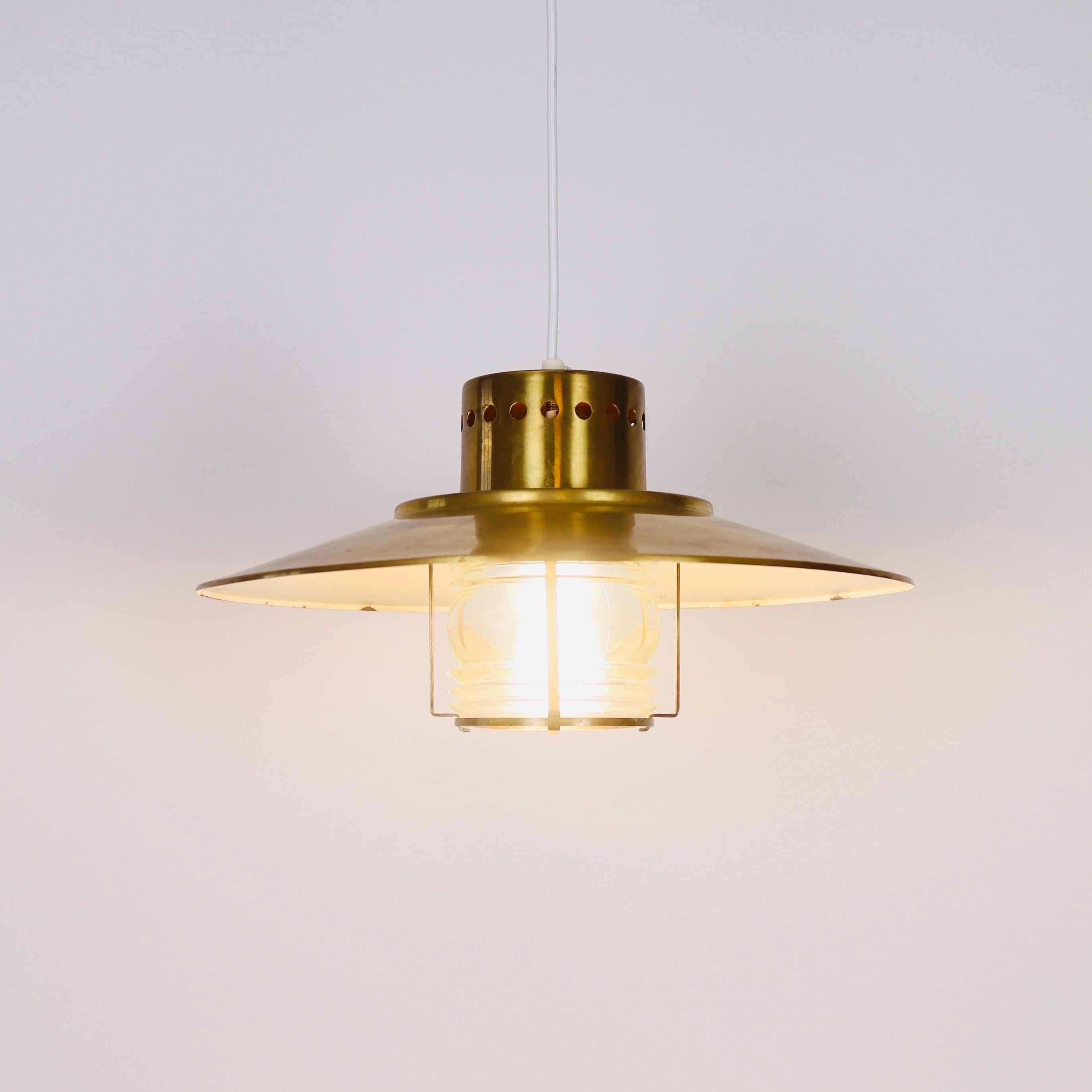 A brass and glass pendant light designed Svend Aage Holm Sørensen in the 1960s. A maritime addition to a modern setting. 

* A brass pendant light with an inner glass shade - eggwhite on the inside.  
* Designer: Svend Aage Holm Sørensen
* Style: