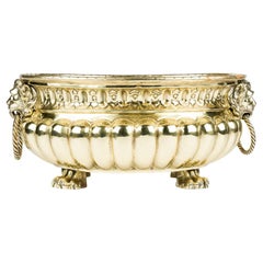 A brass repoussé jardinière with ring handles and paw feet