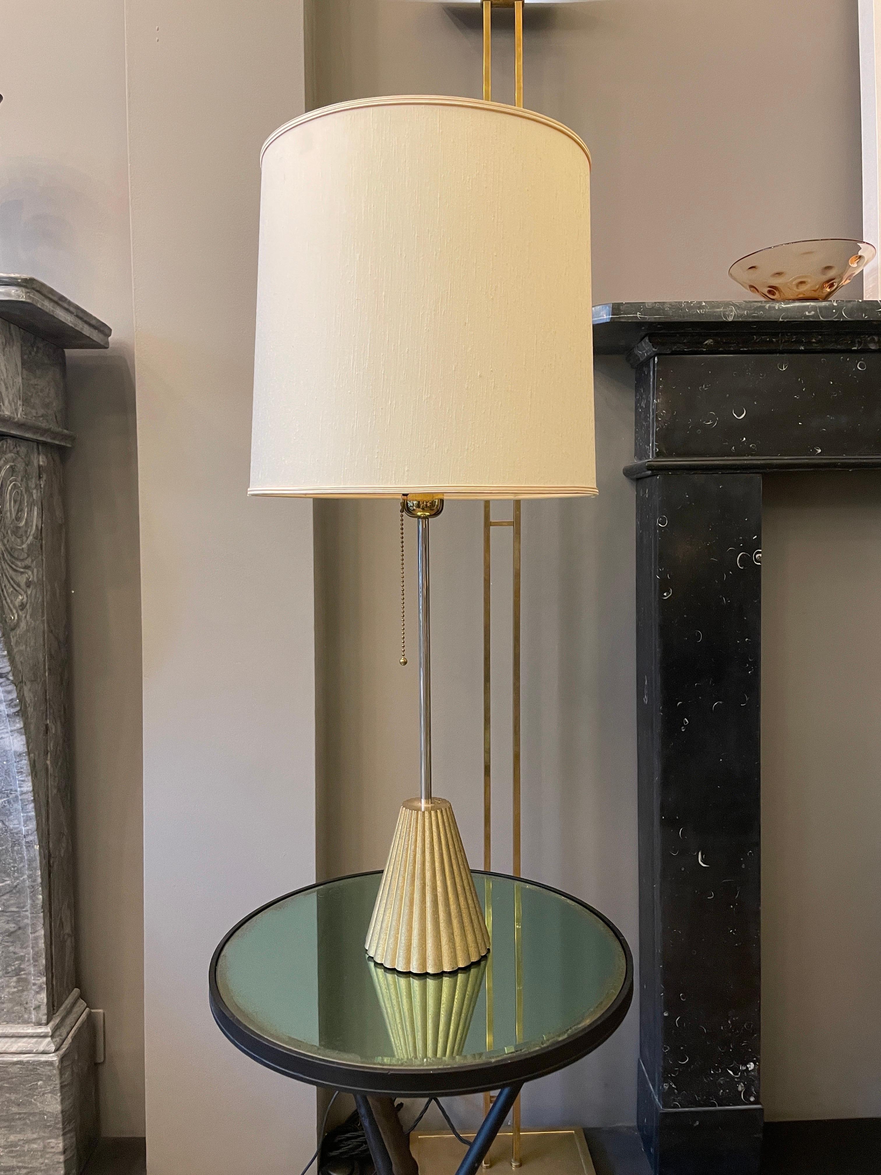 A tall cast brass and chrome table lamp by Peter Ghyczy. Stamped at top of base, chrome up right, original shade with pull string switch. Rare model.

 
