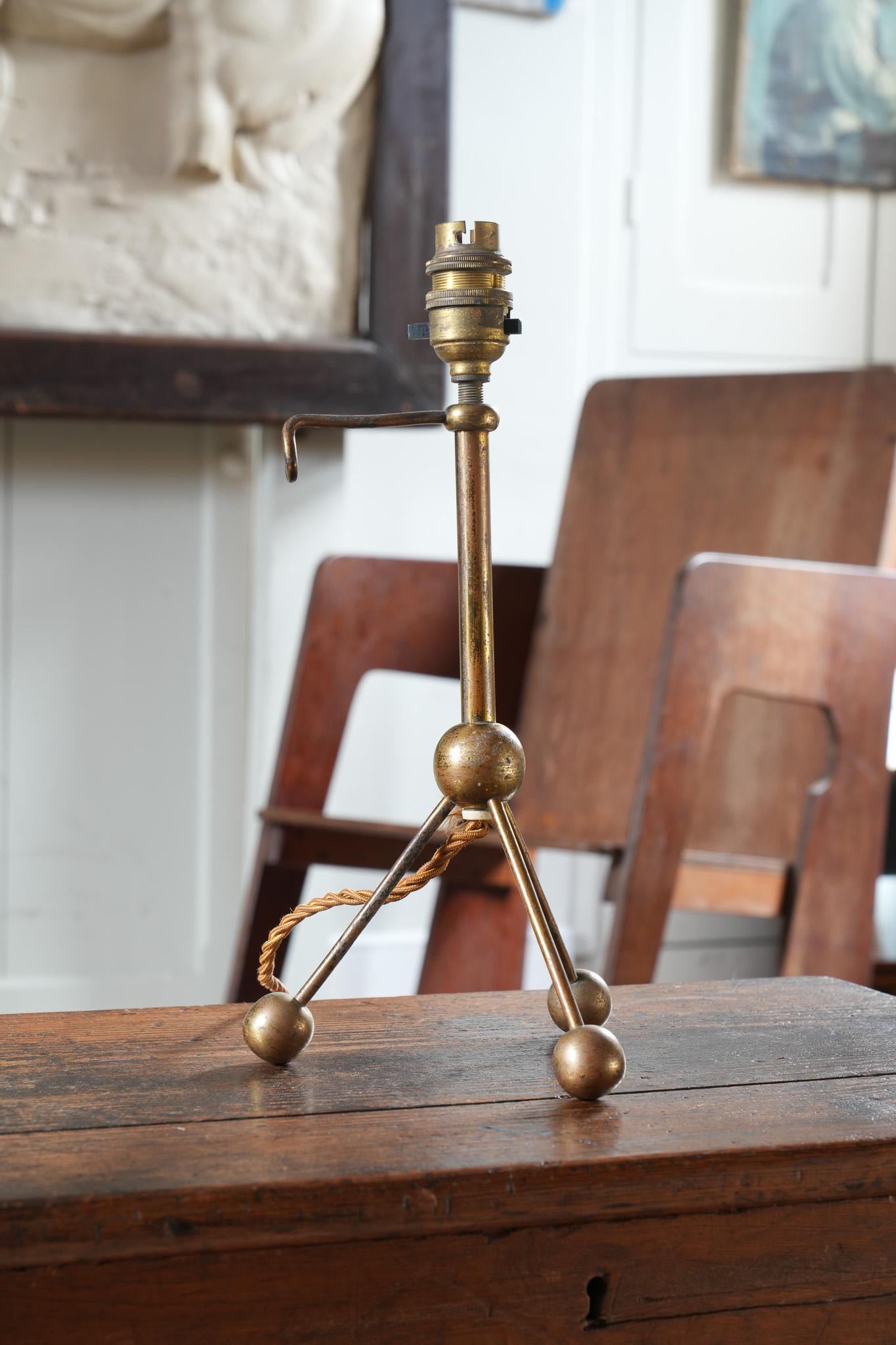 A gilt brass tripod table light. 

Unusually forward thinking form.