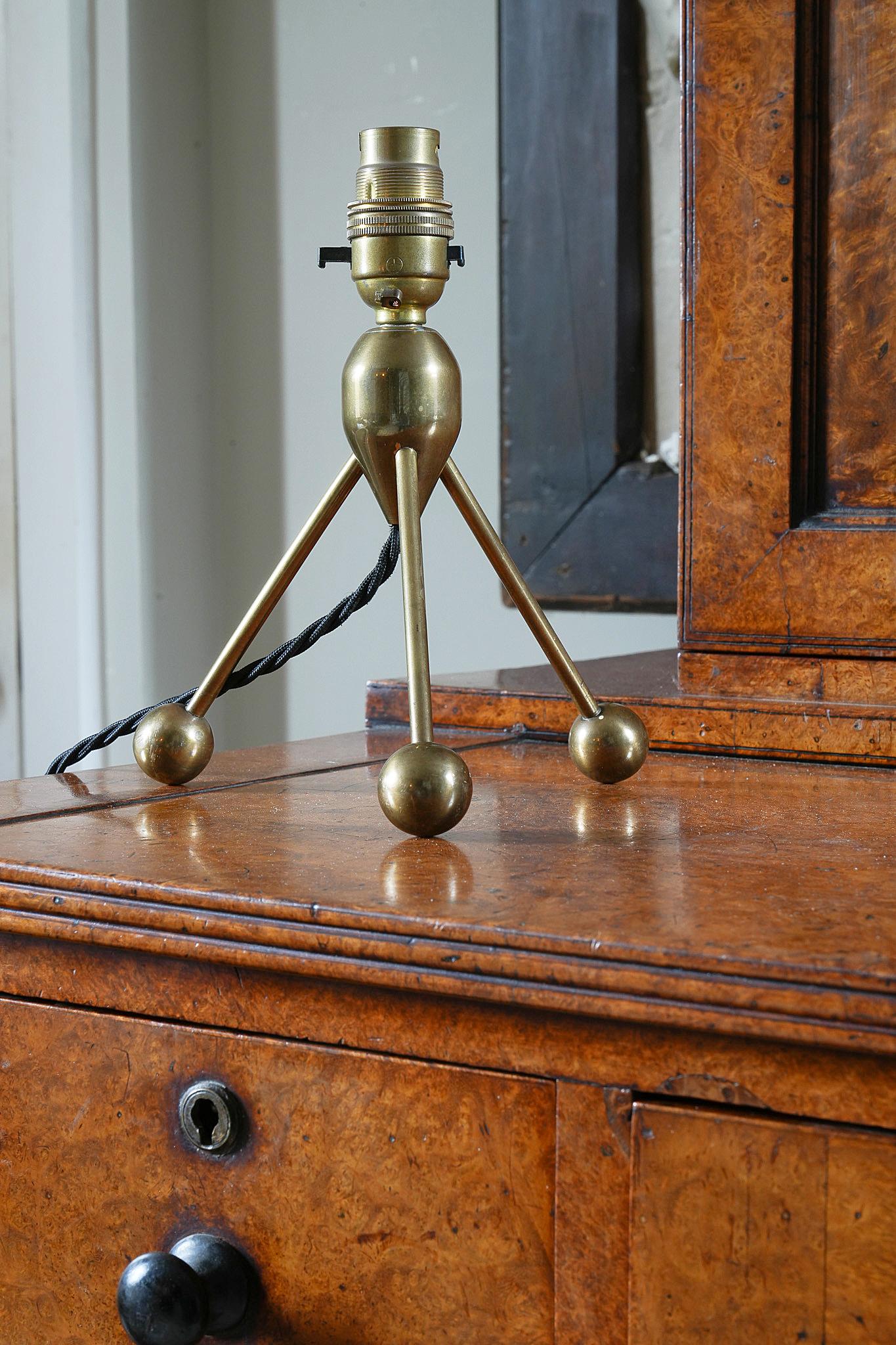 A brass tripod table light raised on ball feet.

