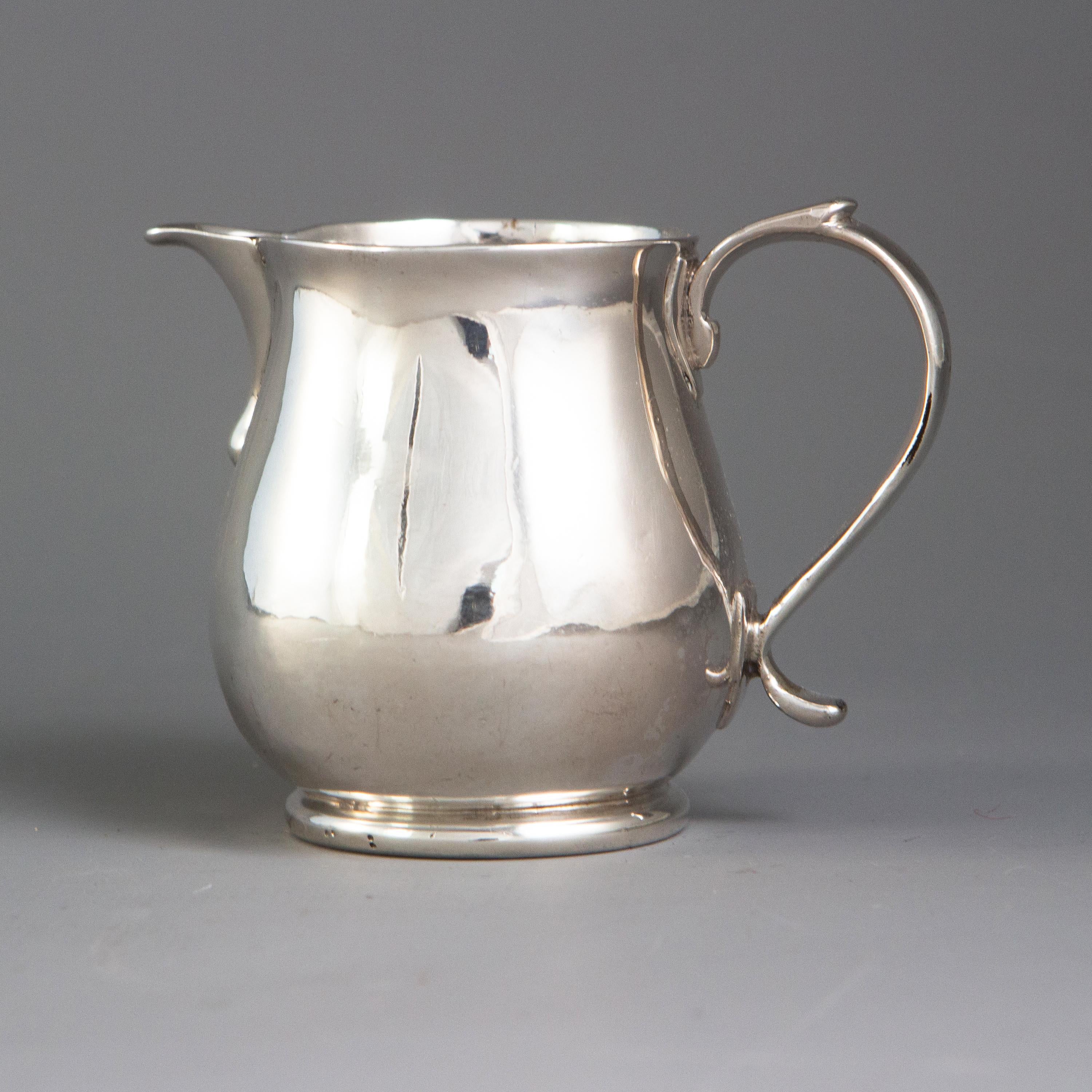 A Britannia silver George I sparrow beak cream jug of raised, bulbous circular form, the plain sparrow beak spout rising from the body with a drop decoration. A scrolling C-shaped handle, with applied thumbpiece. All standing on a circular band