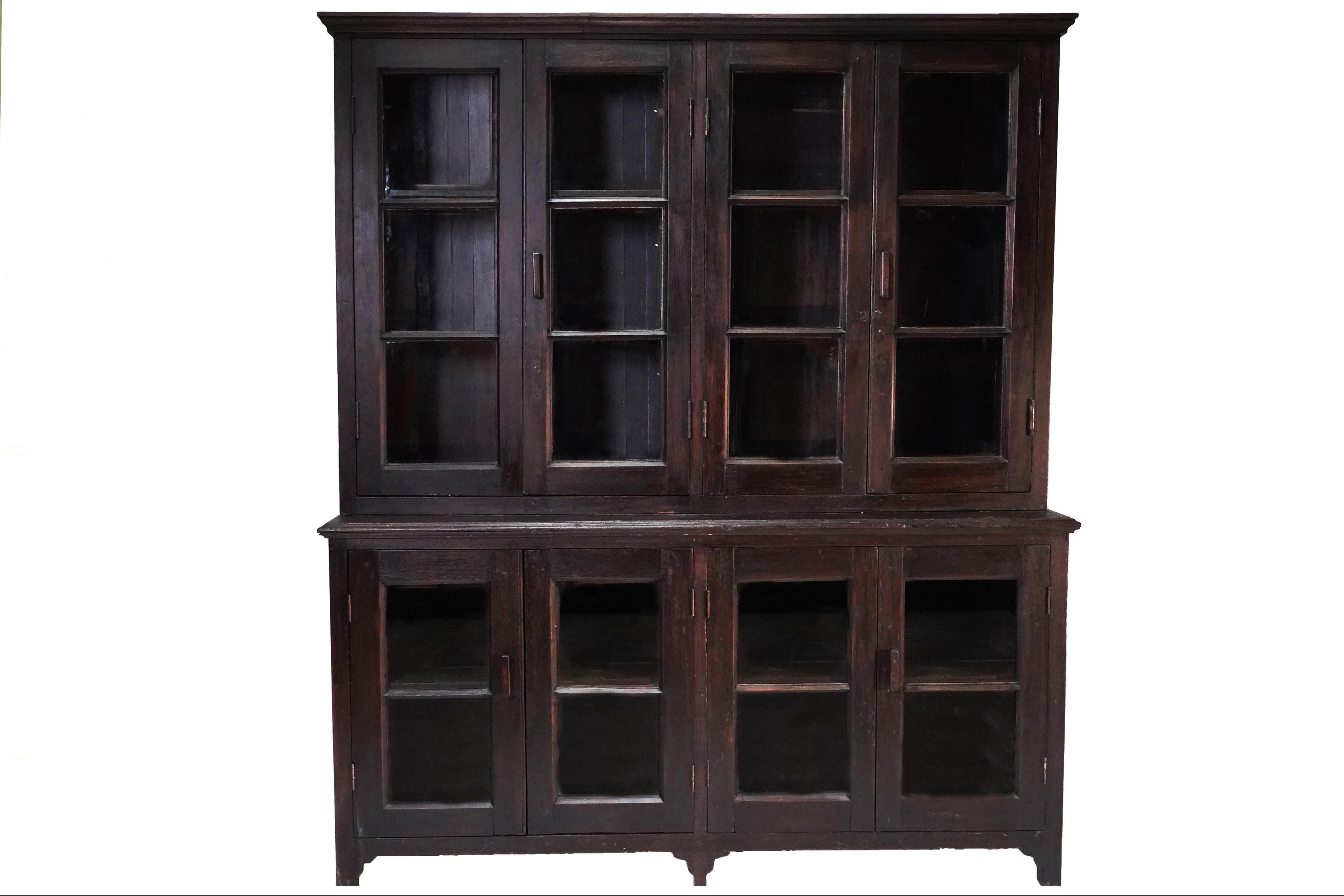 This large antique book cabinet was made from solid teak wood and dates to the early 1900's. During the British Empire in India and Burma much furniture was made in the Anglo-Indian style using native hardwoods and native craftsmen. Styles closely