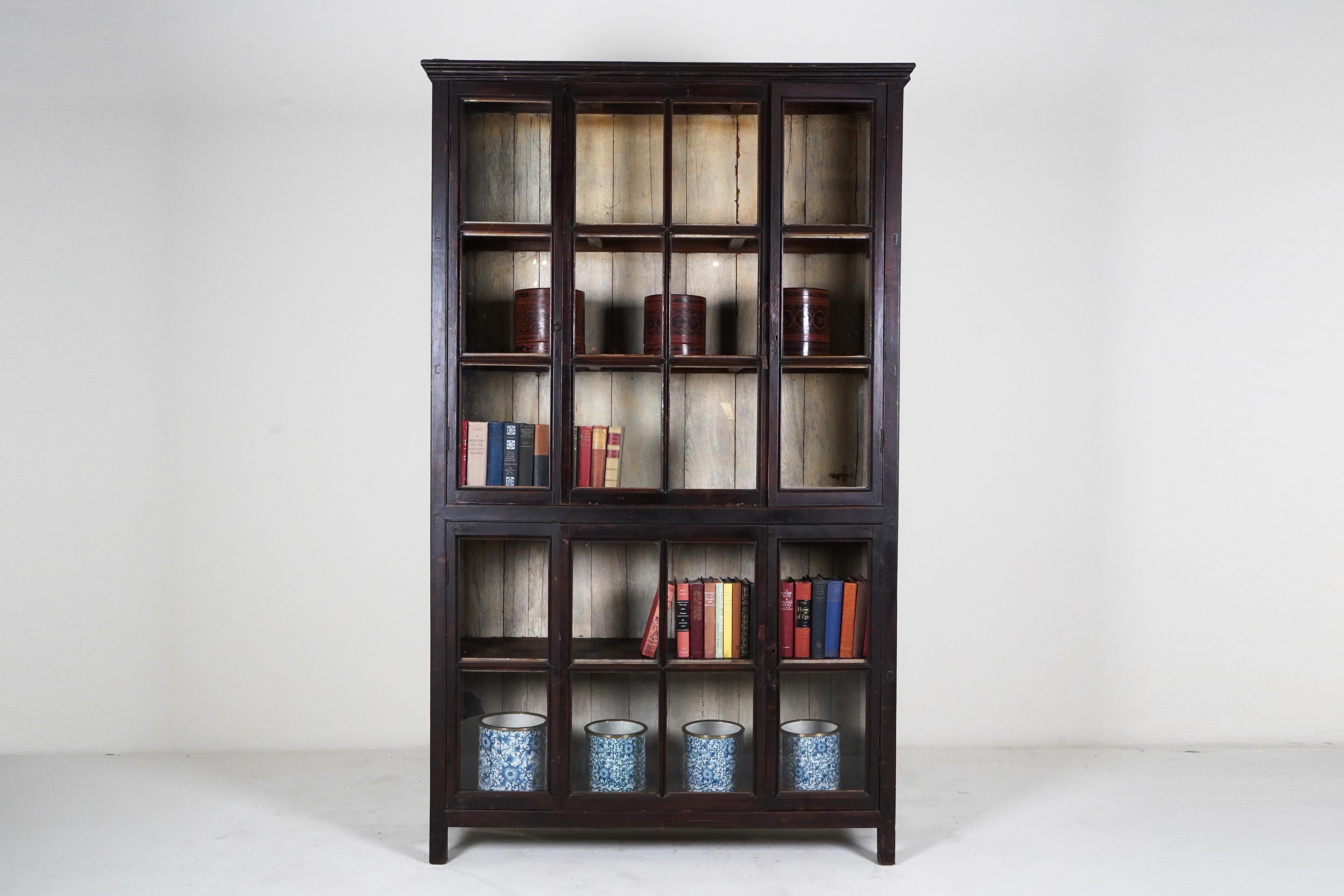 This large antique book cabinet was made from solid teak wood, lacquered black and dates to the early 1900's. During the British Empire in India and Burma, much furniture was made in the Anglo-Indian style using native hardwoods and native