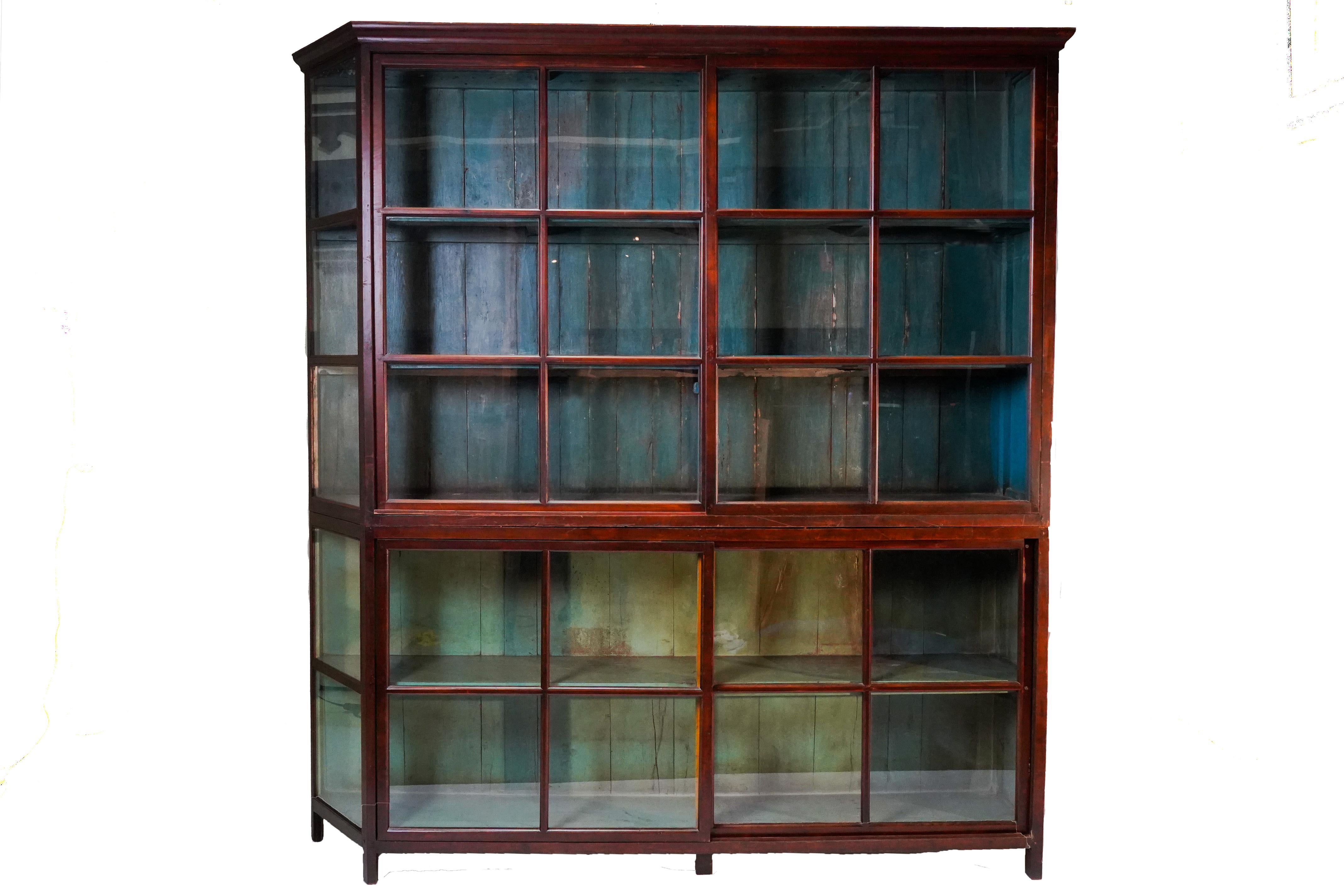 This monumental British book cabinet was made from solid Teak wood and dates to the early 1900's. During the late British Empire in India and Burma much furniture was made in the Anglo-Indian style using native hardwoods and native craftsmen.  