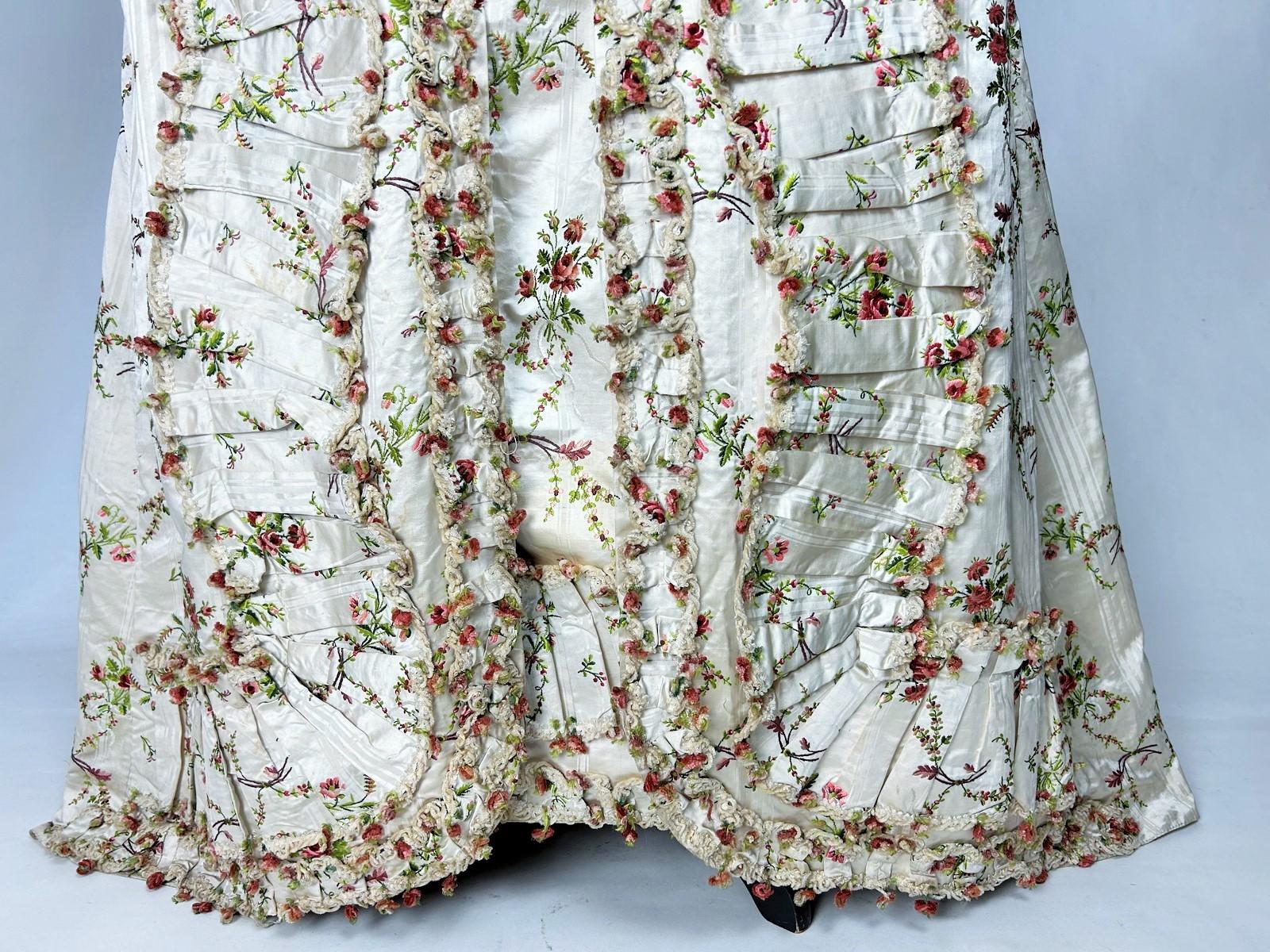 Circa 1780
France
French dress in brocaded pekin satin, Watteau pleated coat, pagoda sleeves and basket skirt, possibly for the Court.  Cream pekin satin with fluted stripes and brocaded undulating stems loaded with rosebuds. Coat with train and