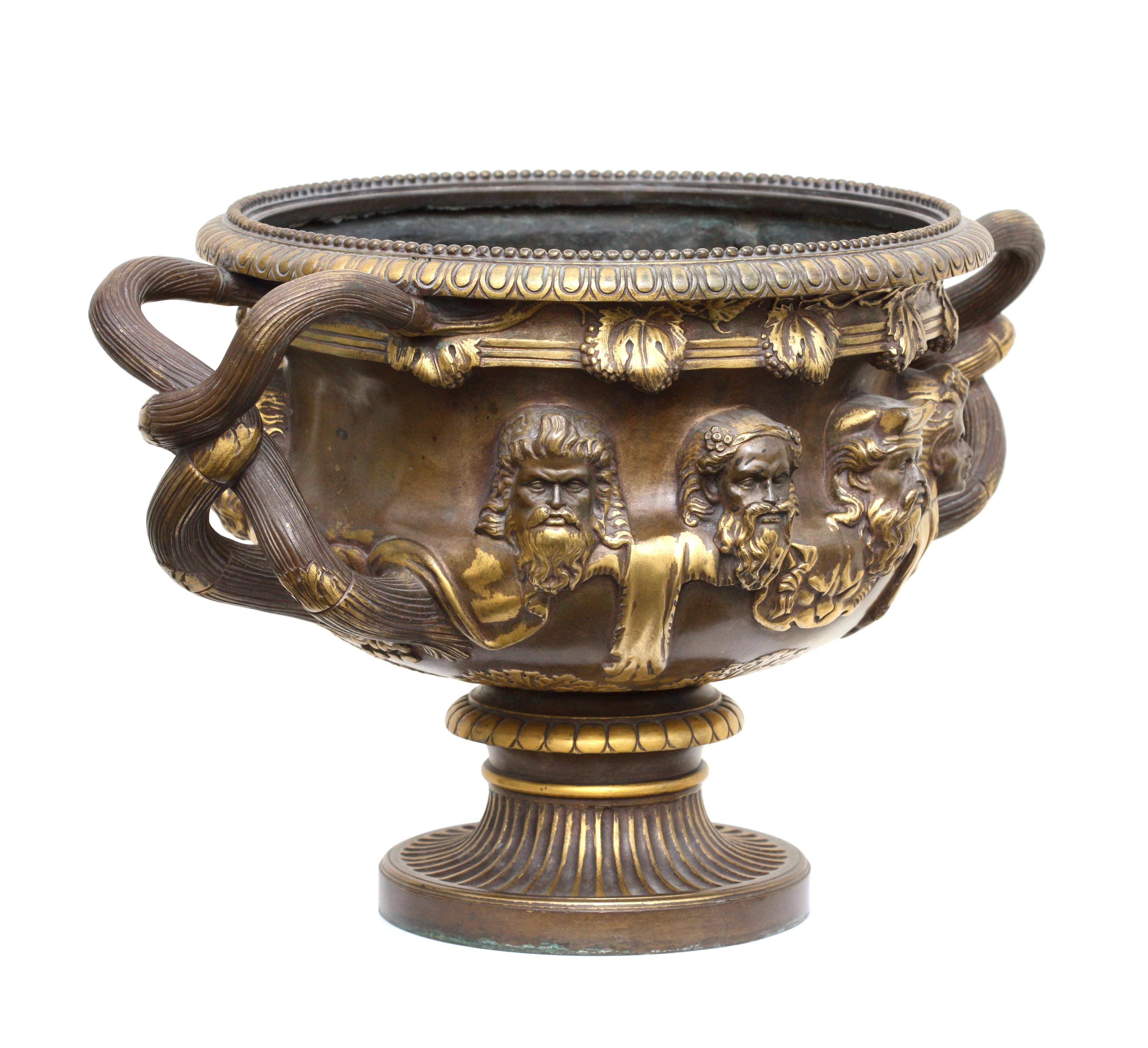 A bronze and gilt bronze 'Warwick' vase by Barbedienne, Paris, circa 1870, modeled after the original, the masks between the entwined vine handles, egg-and-dart rim, with grapevine decoration, tapering foot on a round pedestal,
Measures: Height 11