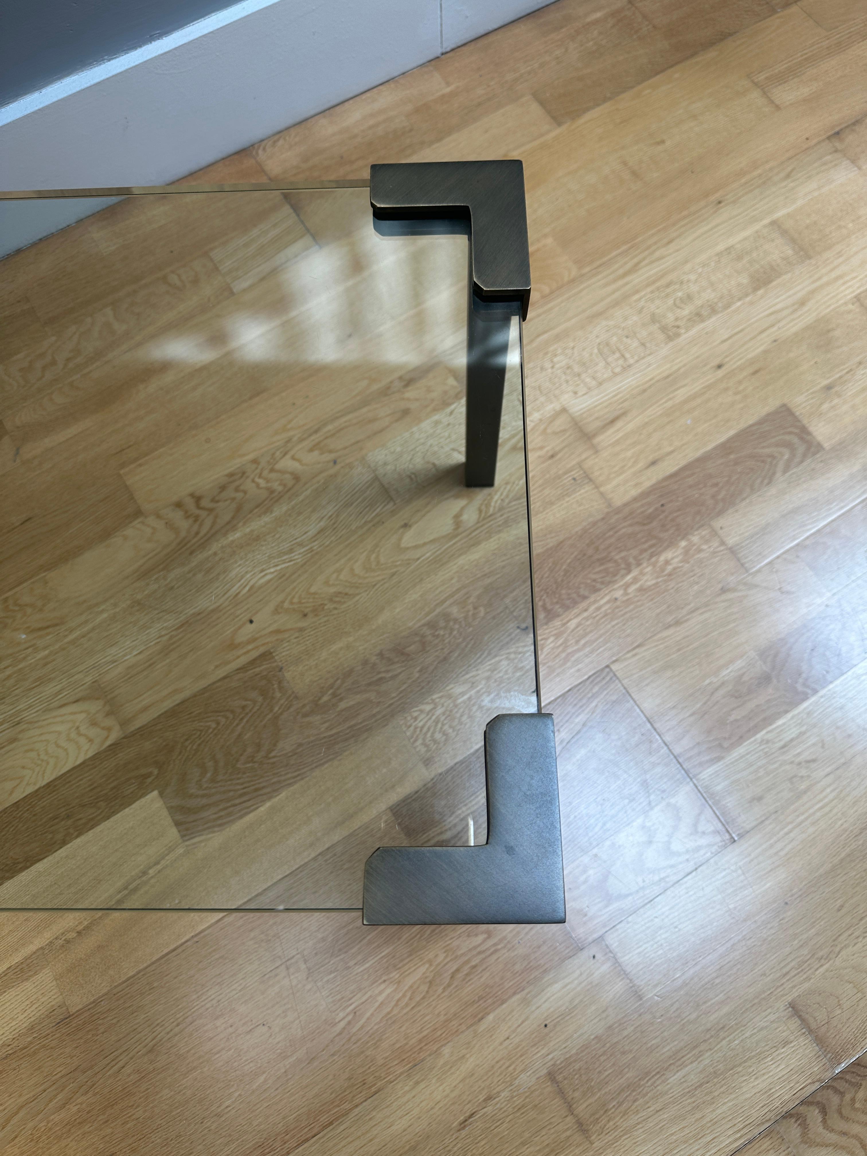 Table de cocktail ou table basse de forme rectangulaire avec une épaisse plaque de verre et des supports en bronze, estampillée avec des marques PG sur les pieds. 
Une table polyvalente idéale pour les espaces restreints 