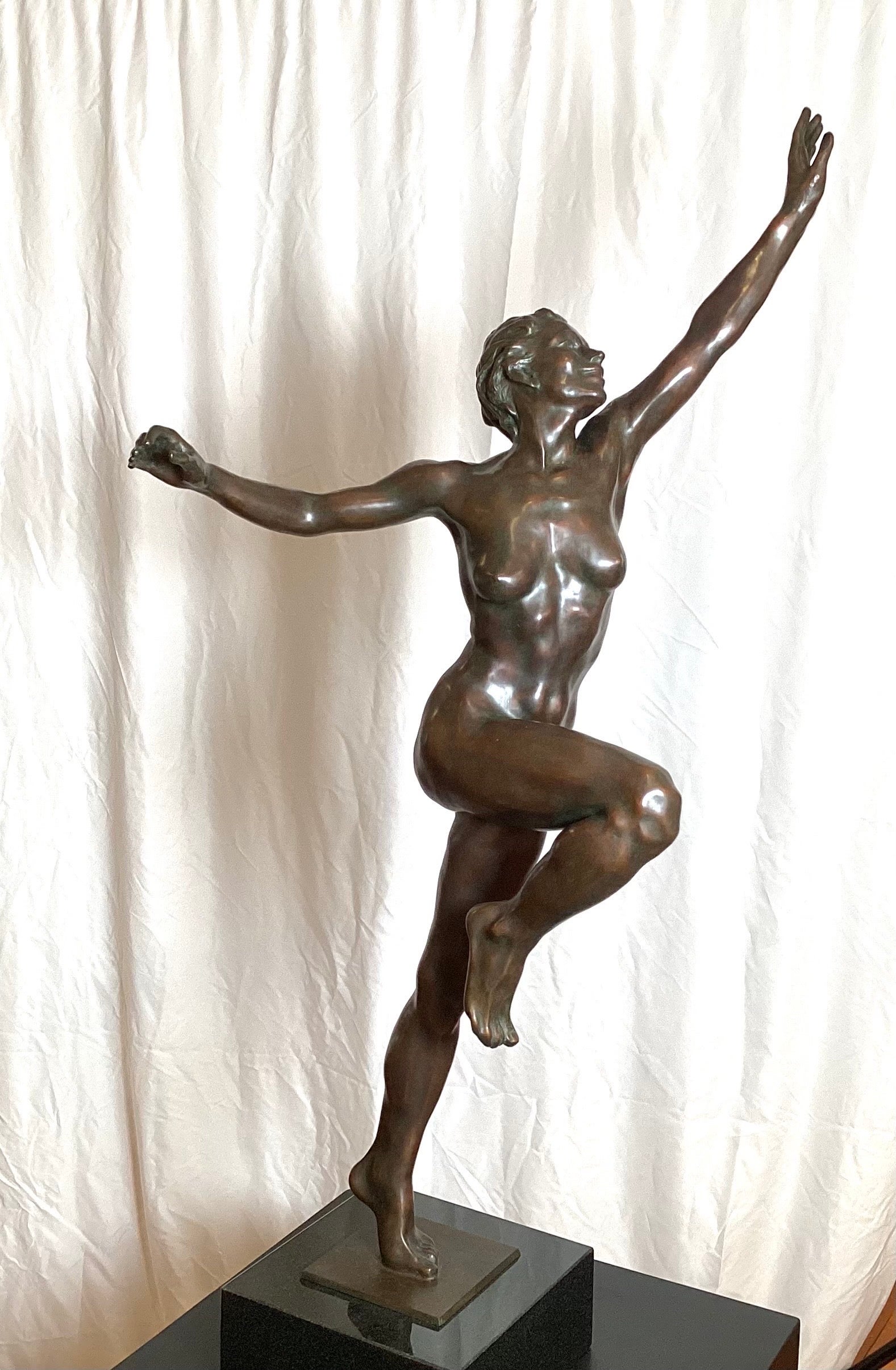 An wonderful patinated bronze female nude sculpture titled Joy, by Norwegian American Artist Kristen Kokkin. The impressive bronze on a dark marble base conveys a sense of joy and measures 46 inches high.  CIrca 1980's

Kokkin made her debut at the