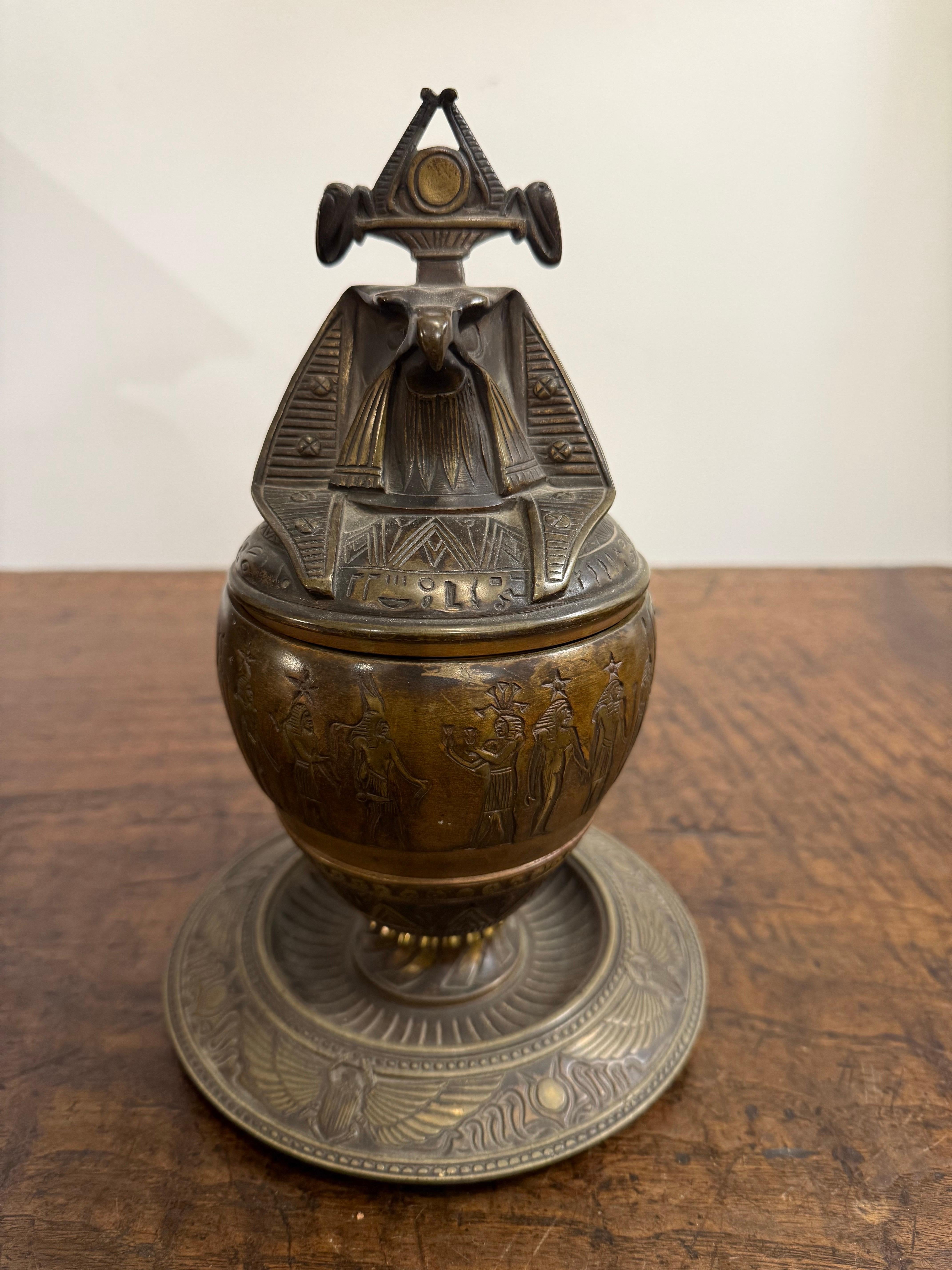 A Bronze Falcon Headed Canopic Jar, Early 20th Century

Description:
The bronze jar with a lid modelled as a zoomorphic falcon-head adorned in a nemes, likely emulating both the gods Qebehsenuef and Ra. One of the four sons of Horus, Qehbehsenuef