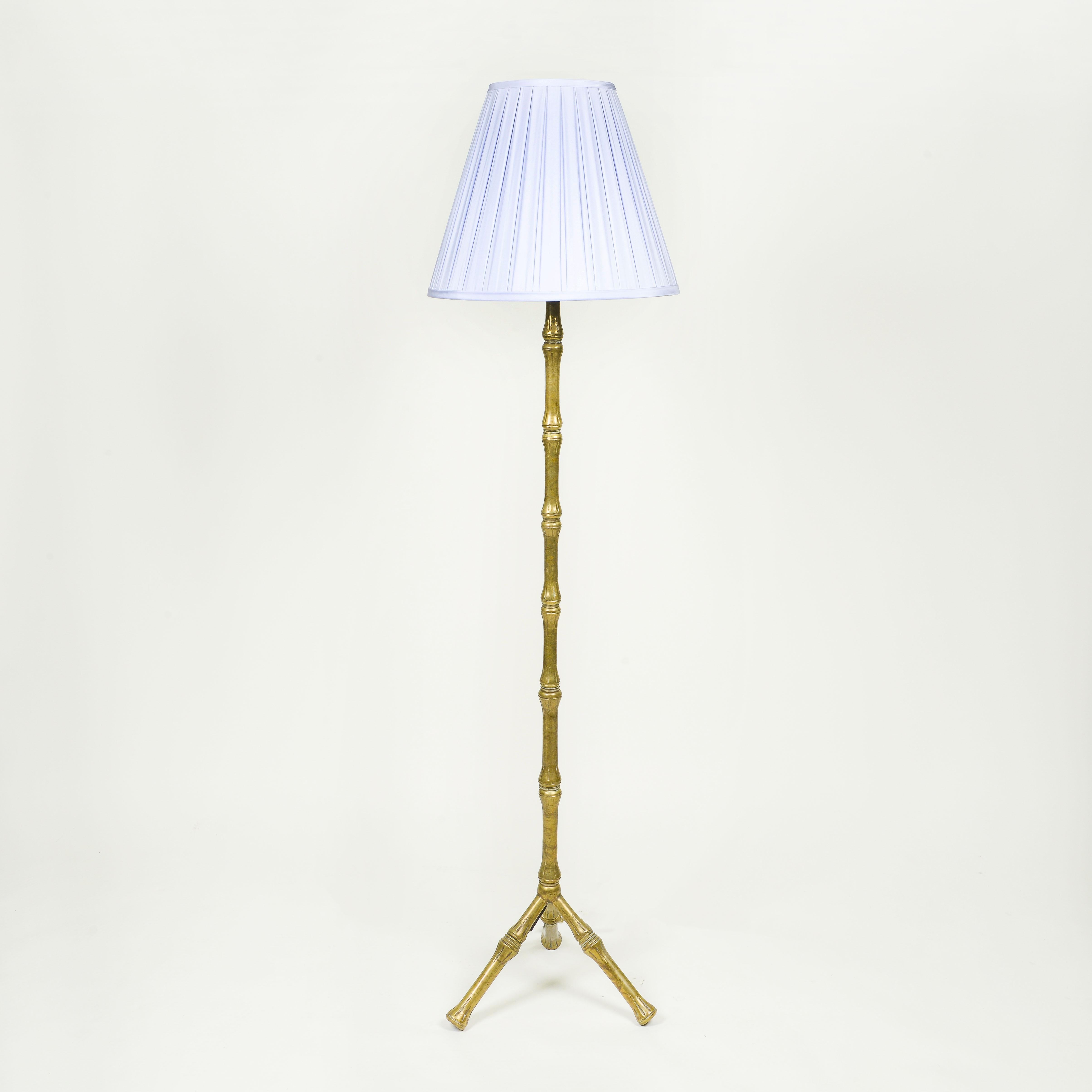 A mid-century French bronze faux bamboo floor lamp featuring a central stem and tripod base.