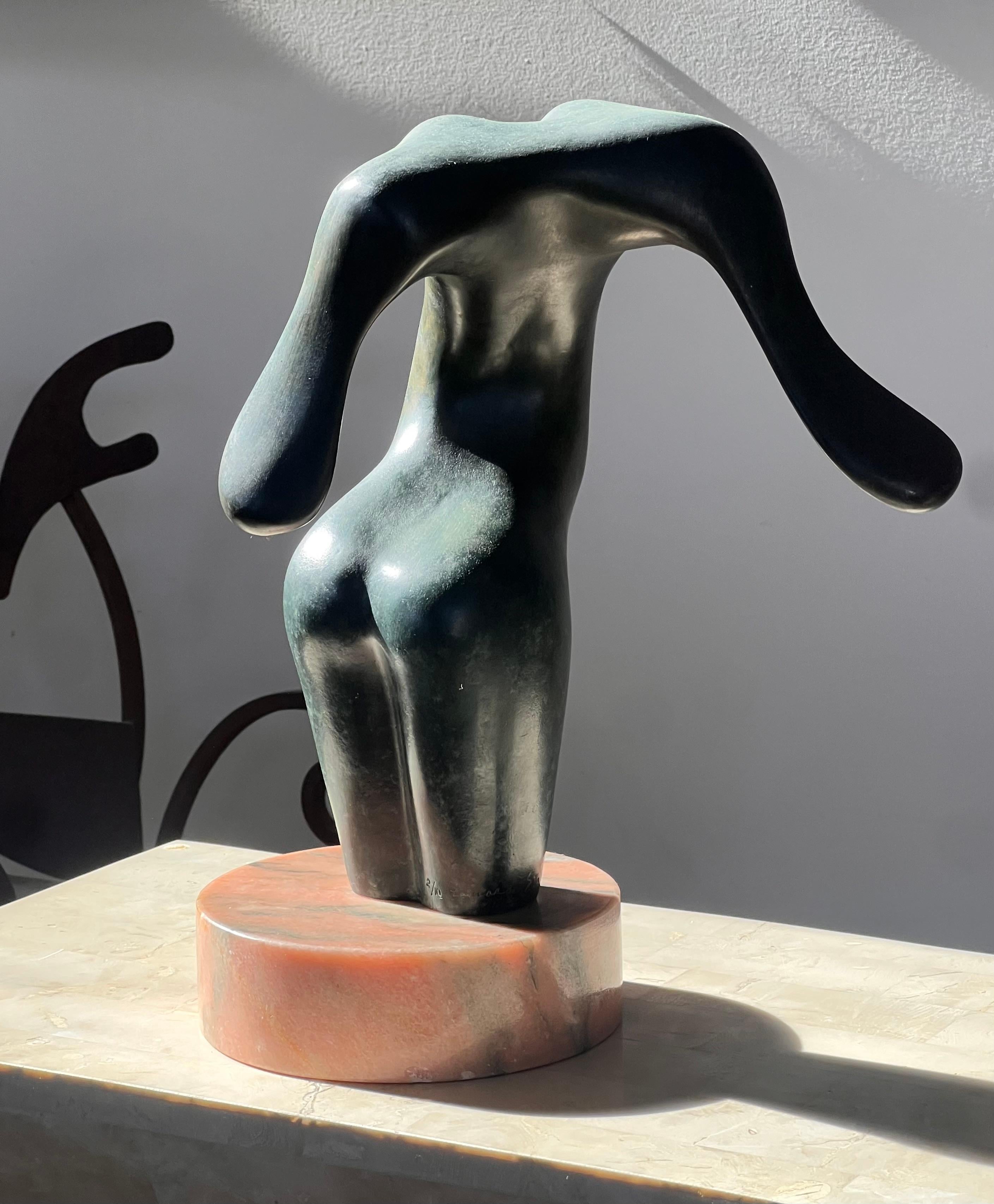 A bronze figurative sculpture depicting an abstract female body, upon a pink marble plinth, signed by artist, probably mid to late 20th century. This piece draws heavy inspiration from the later works of Henry Moore, whose abstracted bronze figures