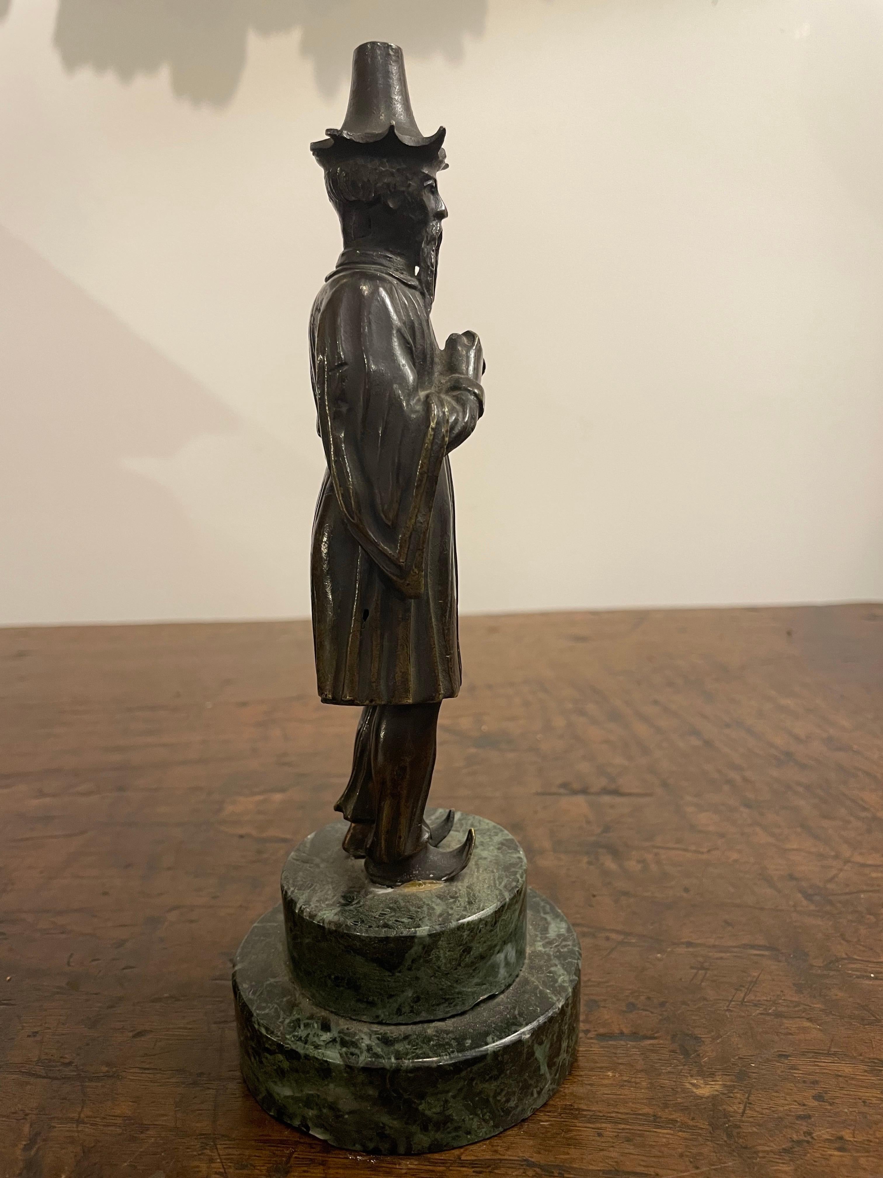 Figura in bronzo di un Manciù su una base di marmo verde, XIX secolo

Provenienza:  
Collezione privata australiana Acquistata nel Regno Unito nel 2006.

Descrizione:
La figura con lunghi baffi e pizzetto, in piedi, vestita in costume tradizionale e