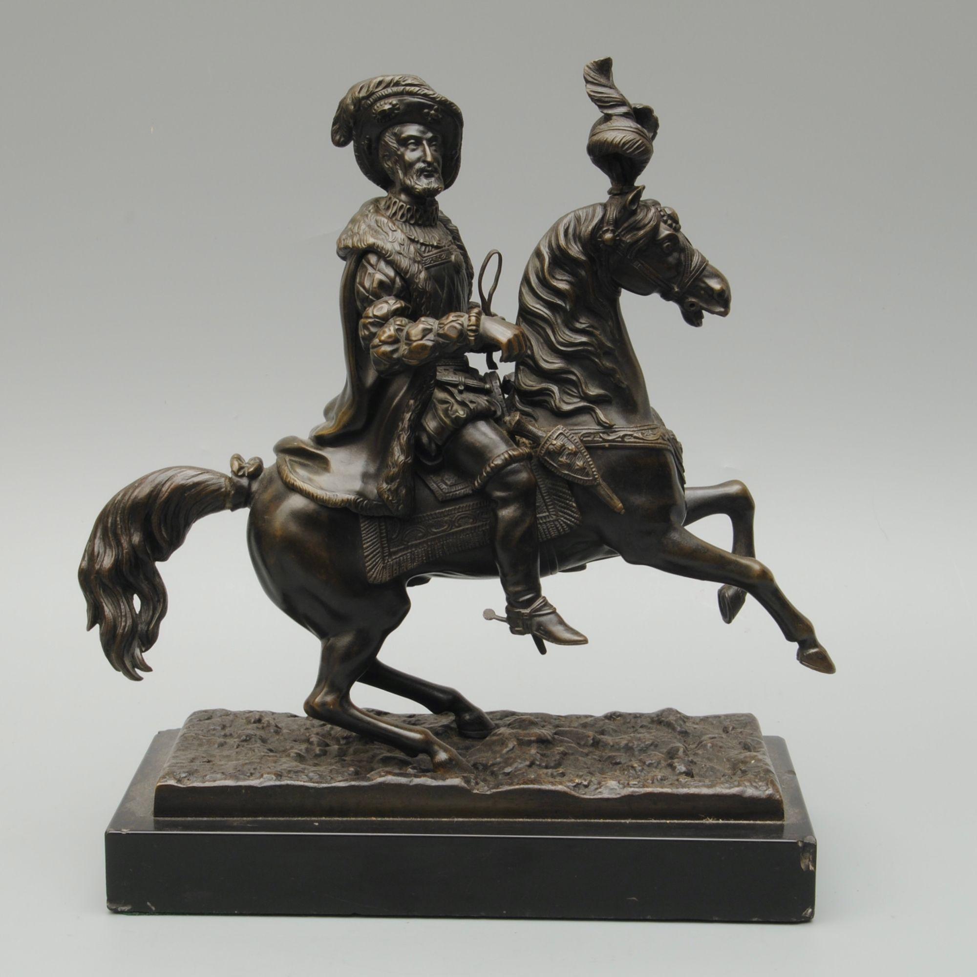 A decorative French bronze figure of Francois 1st on his horse in full dress and the horse with a feather plume. Presented on a black marble base.