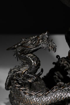 A bronze koro depicting a pair of facing dragons