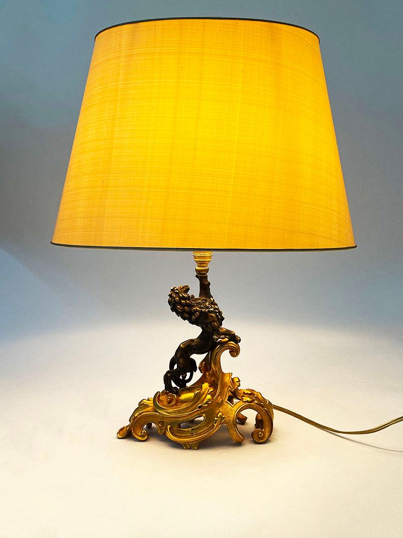 A bronze lamp with curled leaf gilded base and standing lion

Dutch early 20th century bronze lamp
Measures in total with shade 49,5 cm high, 37,5 cm wide and the depth is 29,5
The bronze is 26 cm high, 21 cm wide and the depth is 11 cm
The