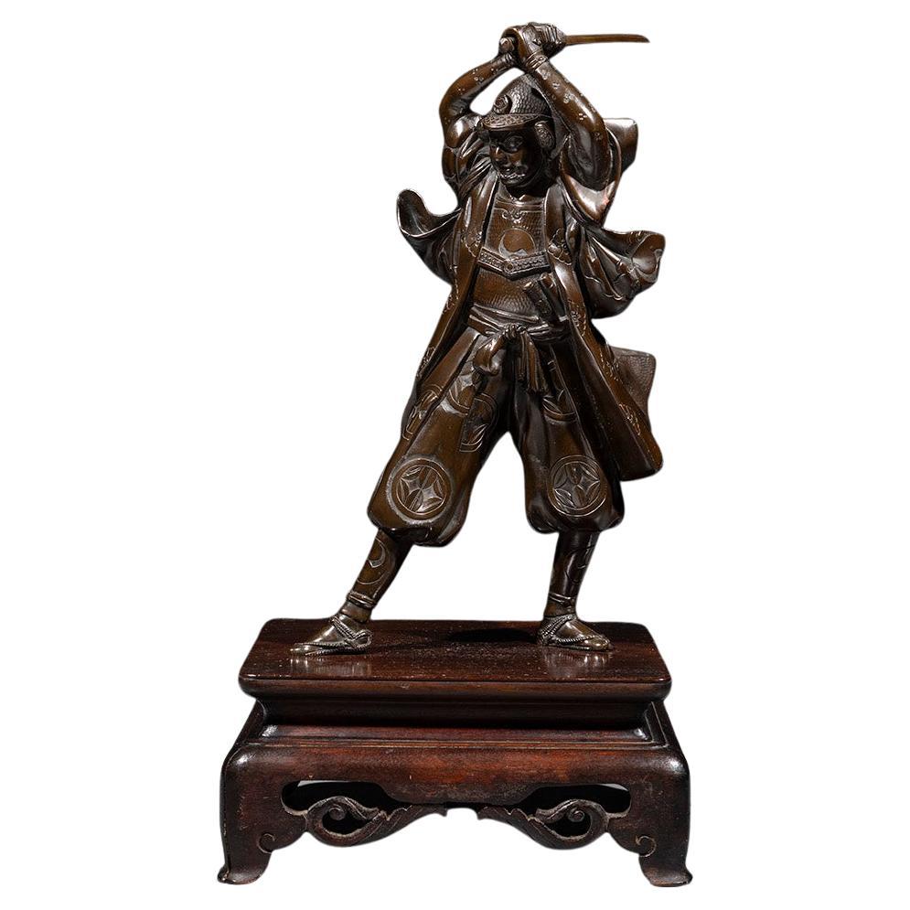 Un okimono in bronzo raffigurante un samurai con una katana, firmato Yoshimitsu