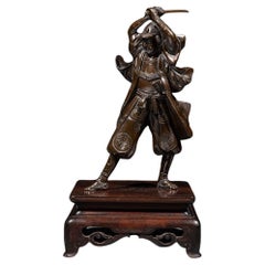 Un okimono in bronzo raffigurante un samurai con una katana, firmato Yoshimitsu