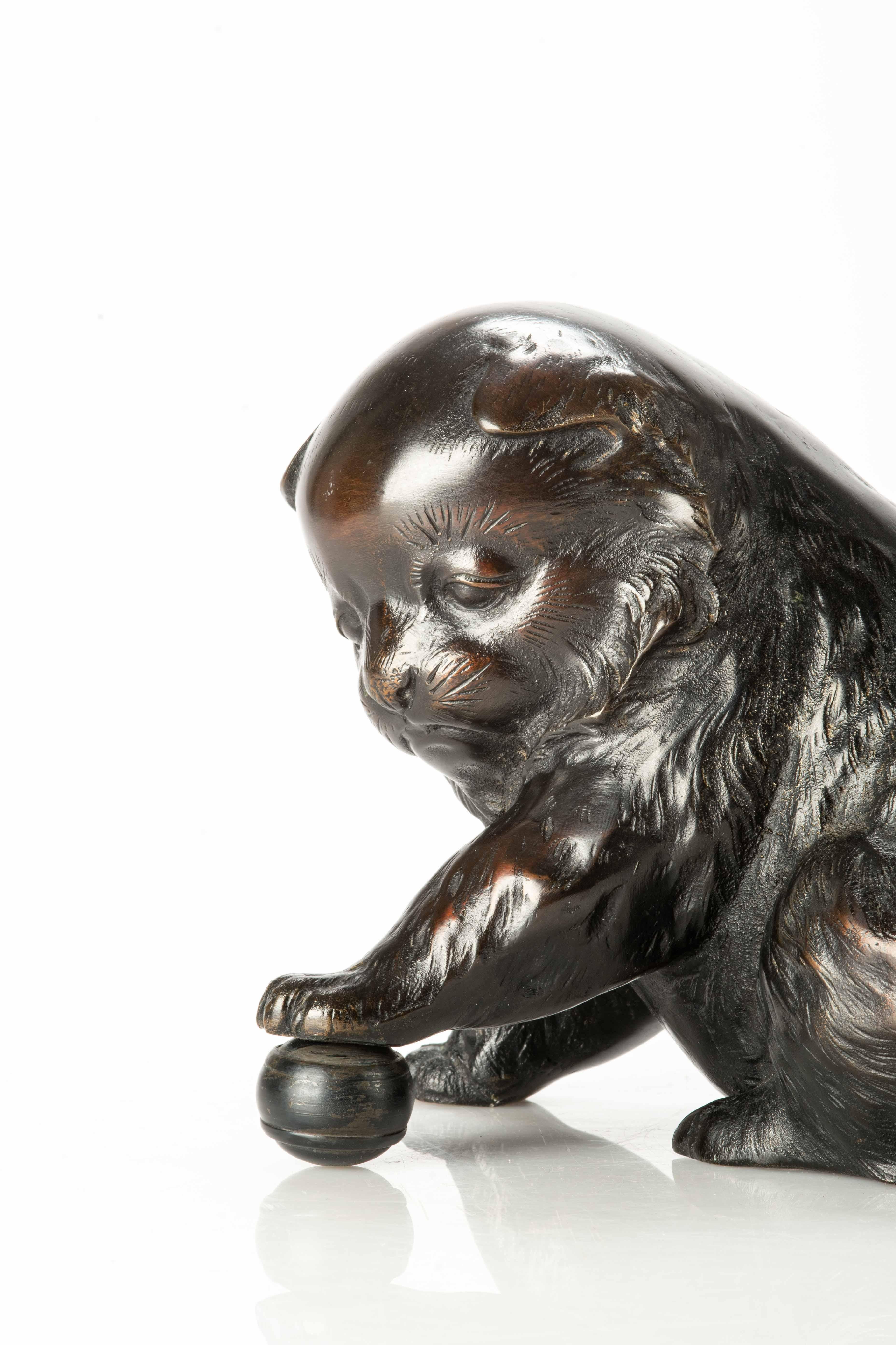 Japonisme A bronze okimono depicting a study of a puppy playing with a ball For Sale
