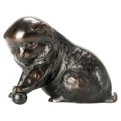 Un okimono de bronce que representa un estudio de un cachorro jugando con una pelota
