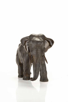 A bronze okimono depicting a walking elephant