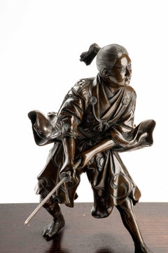 A bronze okimono depicting a young samurai with a katana, signed Yoshimitsu