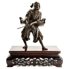 A bronze okimono depicting a young samurai with a katana, signed Yoshimitsu
