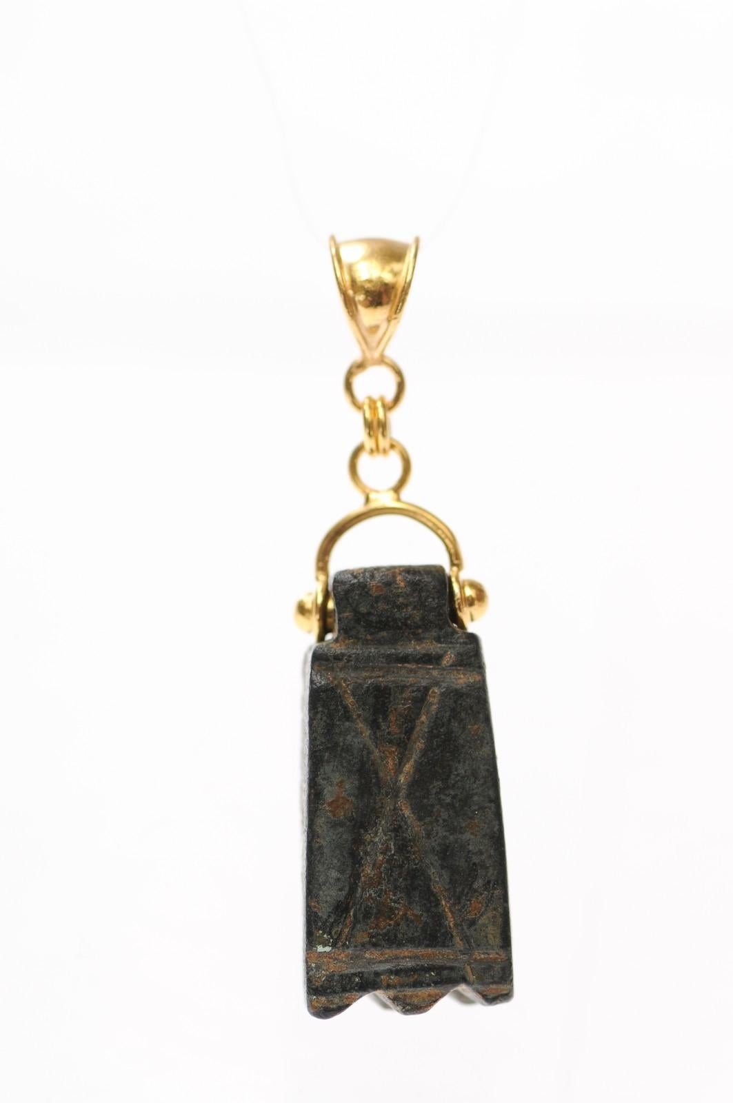 A unique bronze geometric artifact from the Ancient Roman Empire fashioned into a pendant trimmed with 21 karat gold accents and bail. There is a marvelous patina that demonstrates the pendant's age. This is dated approximately from the 1st to 3rd